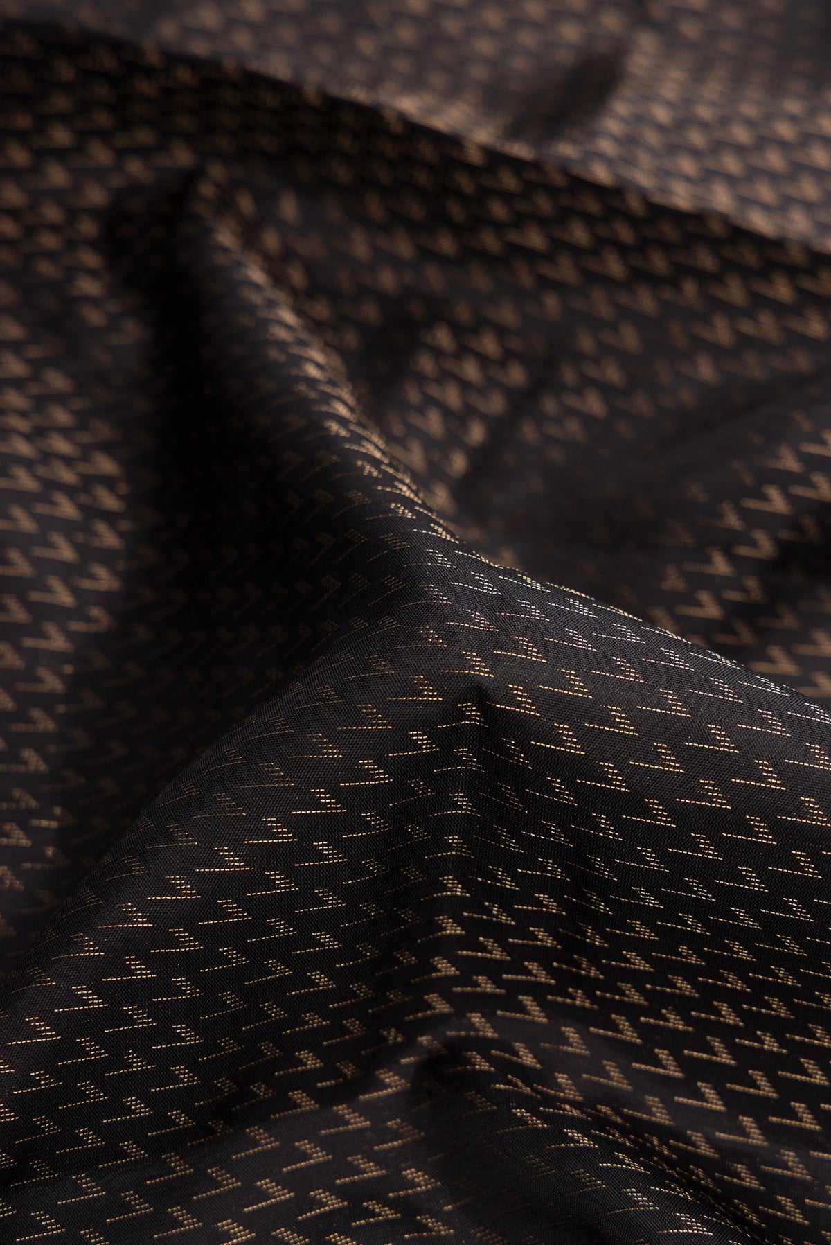 Close up of Black Dual Tone Soft Silk Saree with Zari Brocade on the body and Fancy Border.  displaying folds