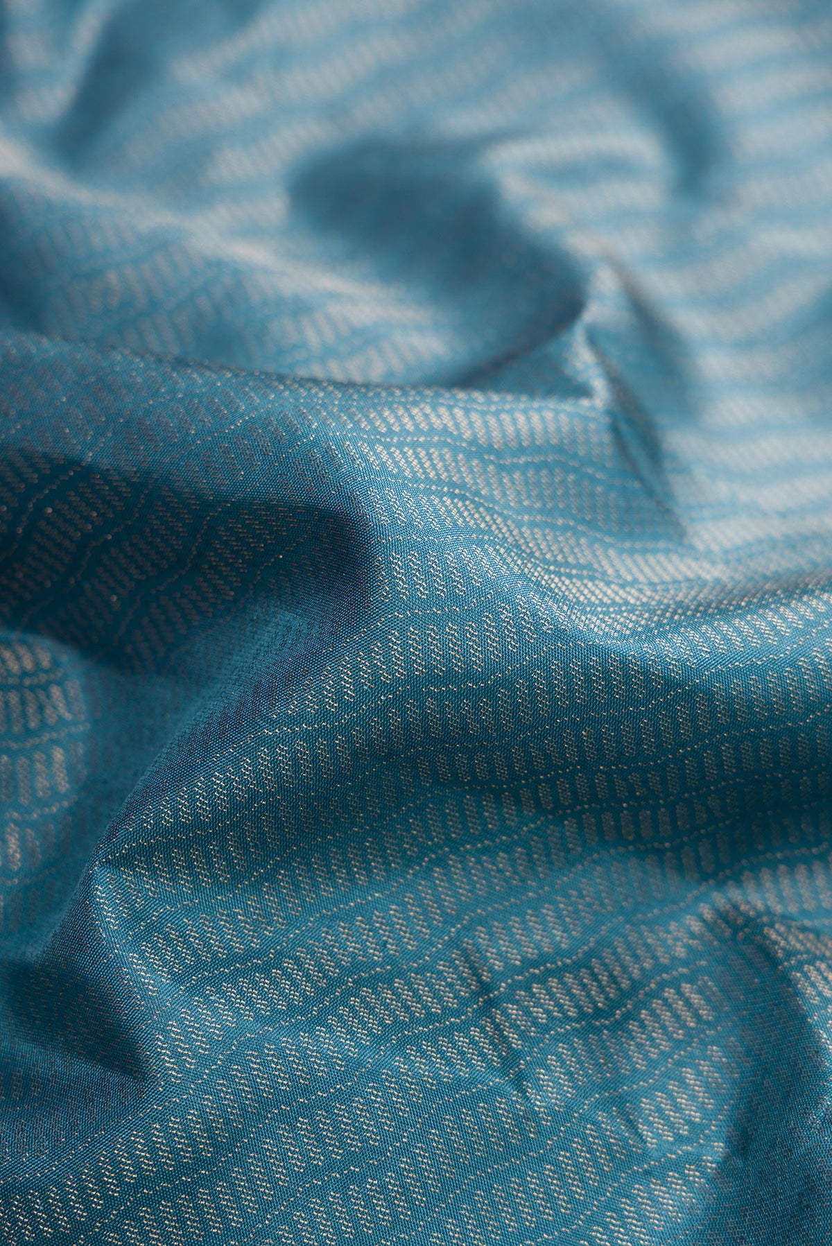 Close up of Maya Blue Dual Tone Soft Silk Saree with Zari Brocade on the body and Fancy Border.  displaying folds