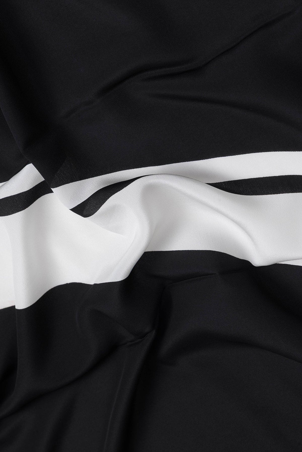 Close up of Black Dual Tone Mysore Crepe Saree with Printed design on the body and Plain Border.  displaying folds