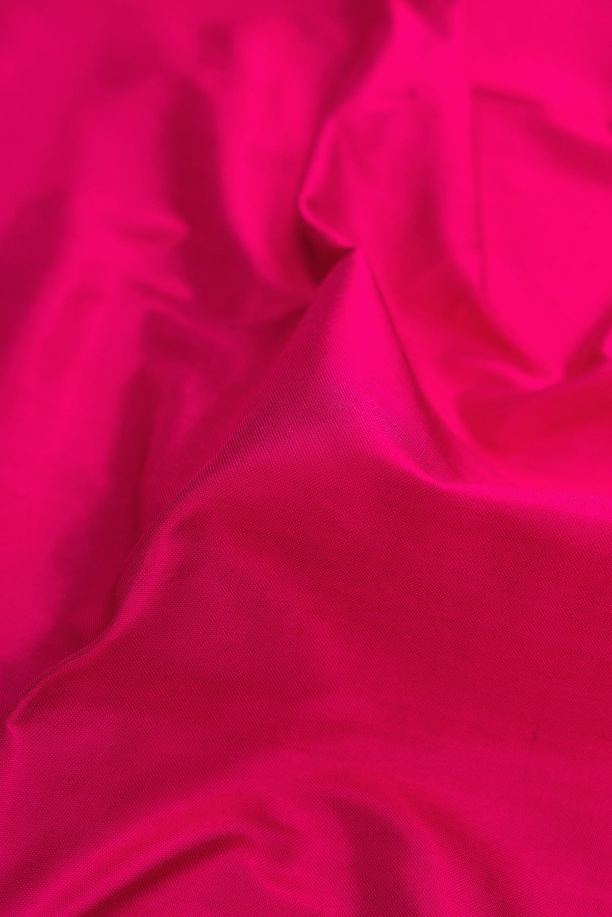 Close up of Dark Pink Dual Tone Double Ikat Saree with Plain Body and Fancy Border.  displaying folds