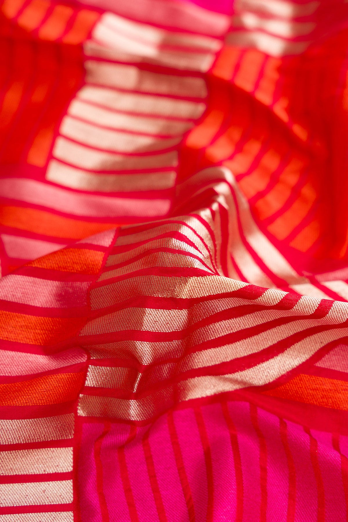Close up of Red Dual Tone Banarasi Silk Saree with Zari Brocade on the body and Zari Border.  displaying folds