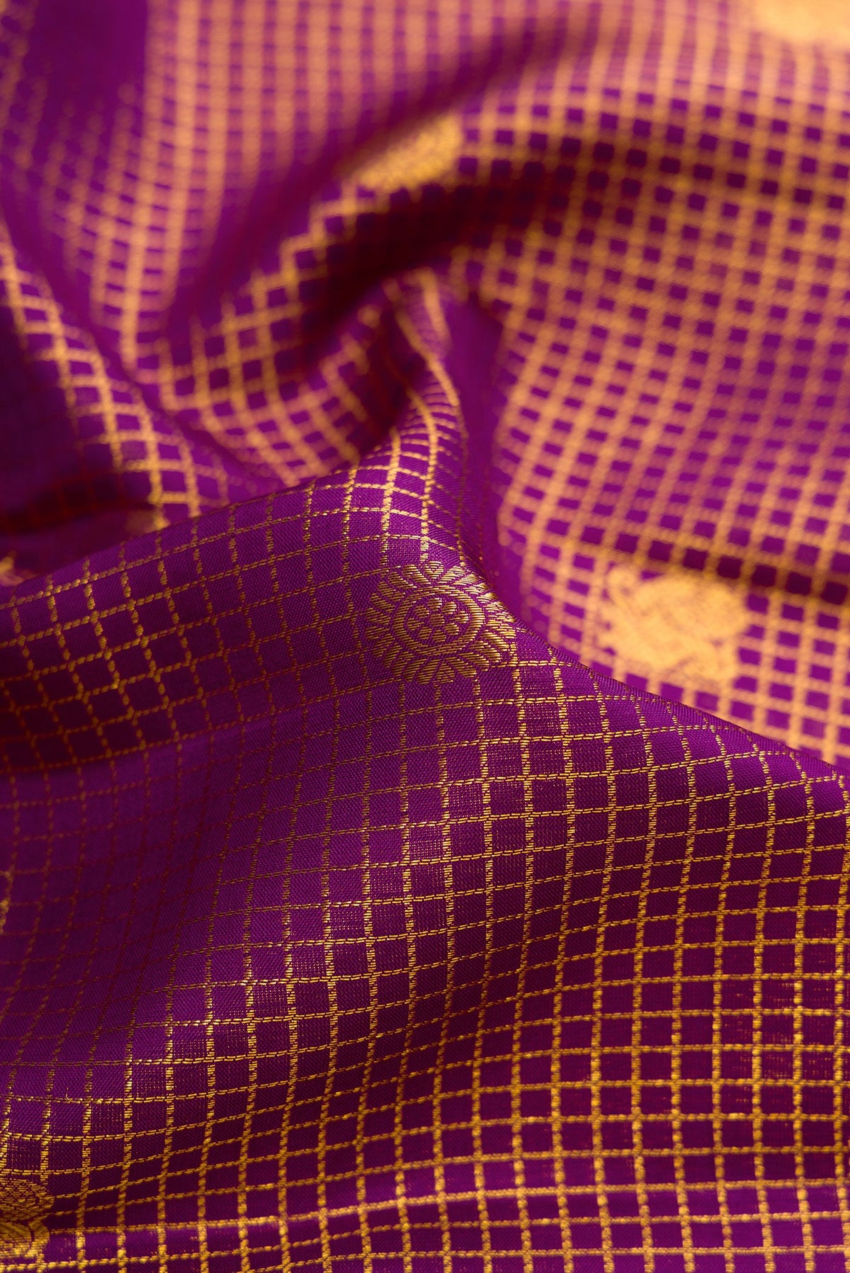 Close up of Violet Dual Tone Kanjivaram Silk Saree with Checked design on the body and Zari Border.  displaying folds