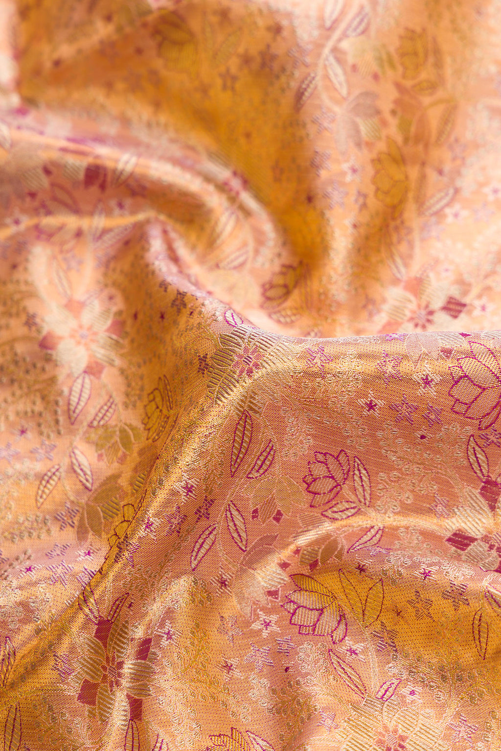 Close up of Peach Dual Tone Kanjivaram Tissue Silk Saree with Zari Brocade on the body and Zari Border.  displaying folds
