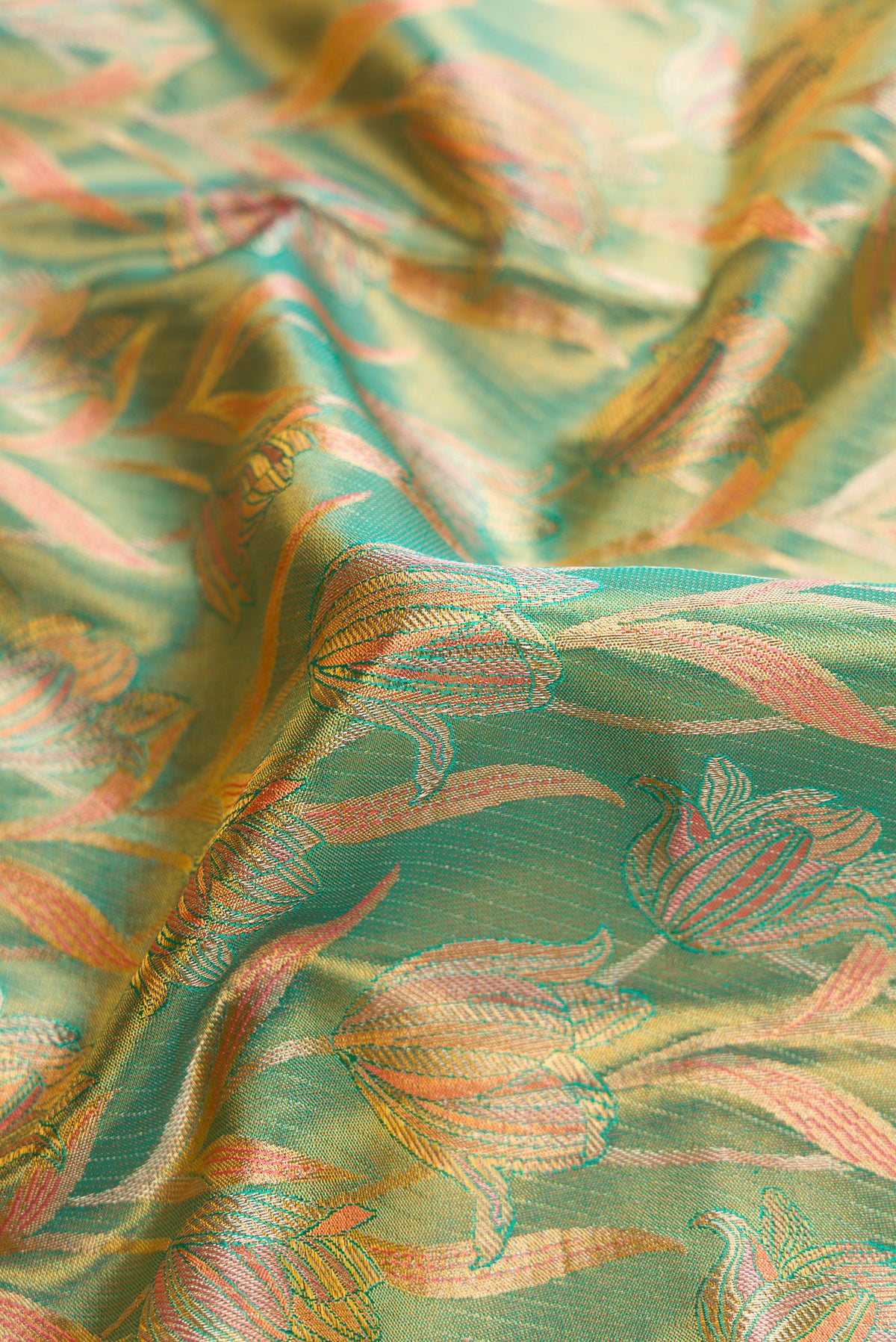 Close up of Green Kanjivaram Tissue Silk Saree with Zari Brocade on the body and Fancy Border.  displaying folds