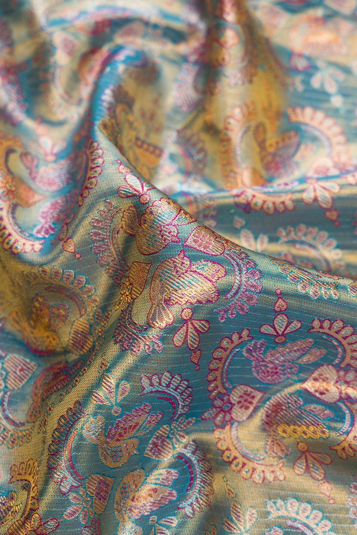 Close up of Light Blue Dual Tone Kanjivaram Tissue Silk Saree with Zari Brocade on the body and Fancy Border.  displaying folds
