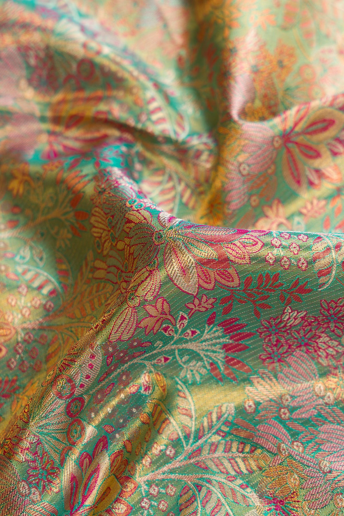 Close up of Sea Green Dual Tone Kanjivaram Tissue Silk Saree with Zari Brocade on the body and Fancy Border.  displaying folds