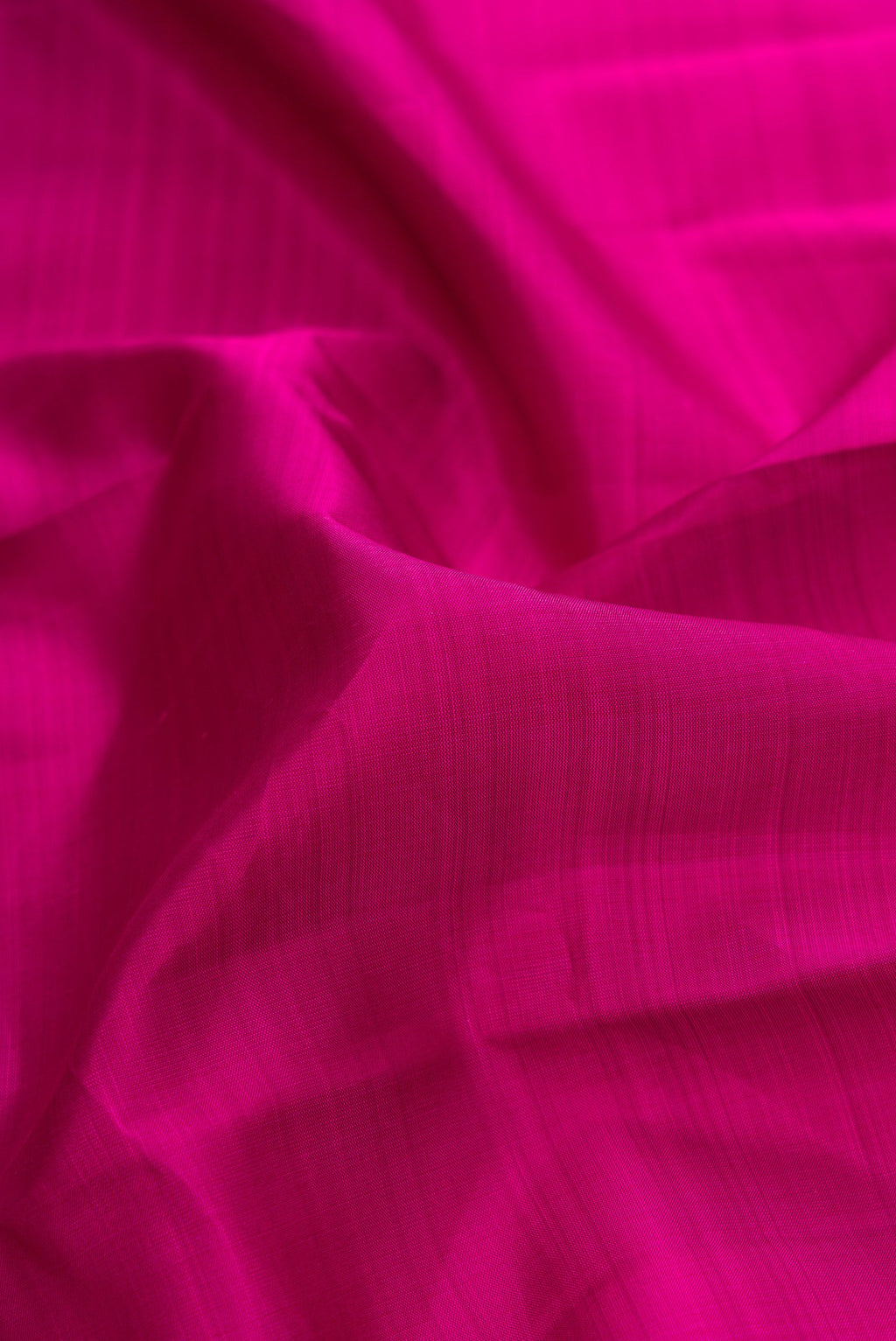 Close up of Magenta Dual Tone Kanjivaram Silk Saree with Plain Body and Zari Border.  displaying folds
