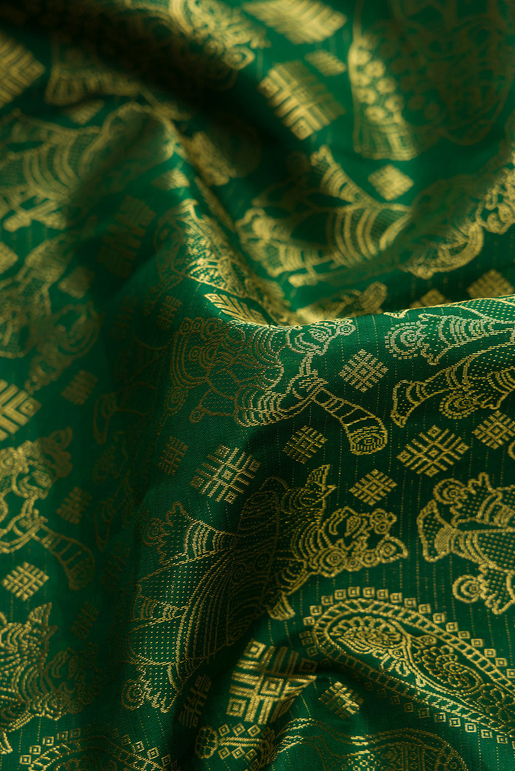 Close up of Green Kanchipuram Silk Saree with Zari Butta on the body and Zari Border.  displaying folds