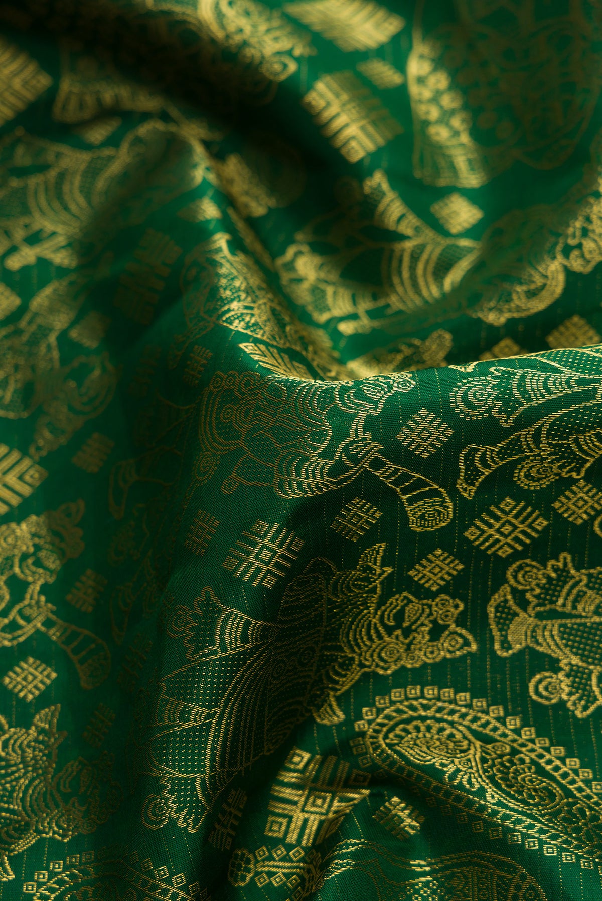 Close up of Green Kanchipuram Silk Saree with Zari Butta on the body and Zari Border.  displaying folds