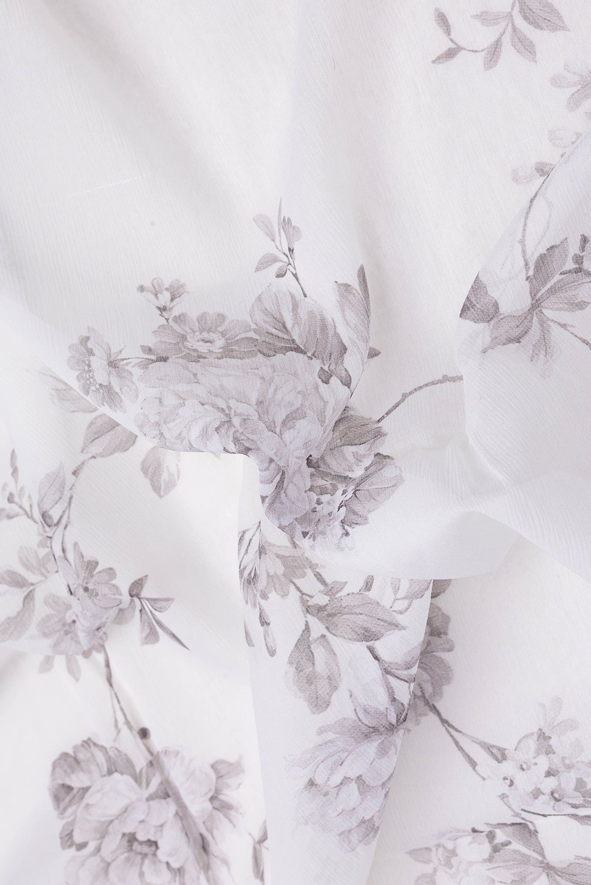 Close up of Off White Dual Tone Mysore Chiffon Saree with Printed design on the body and Plain Border.  displaying folds