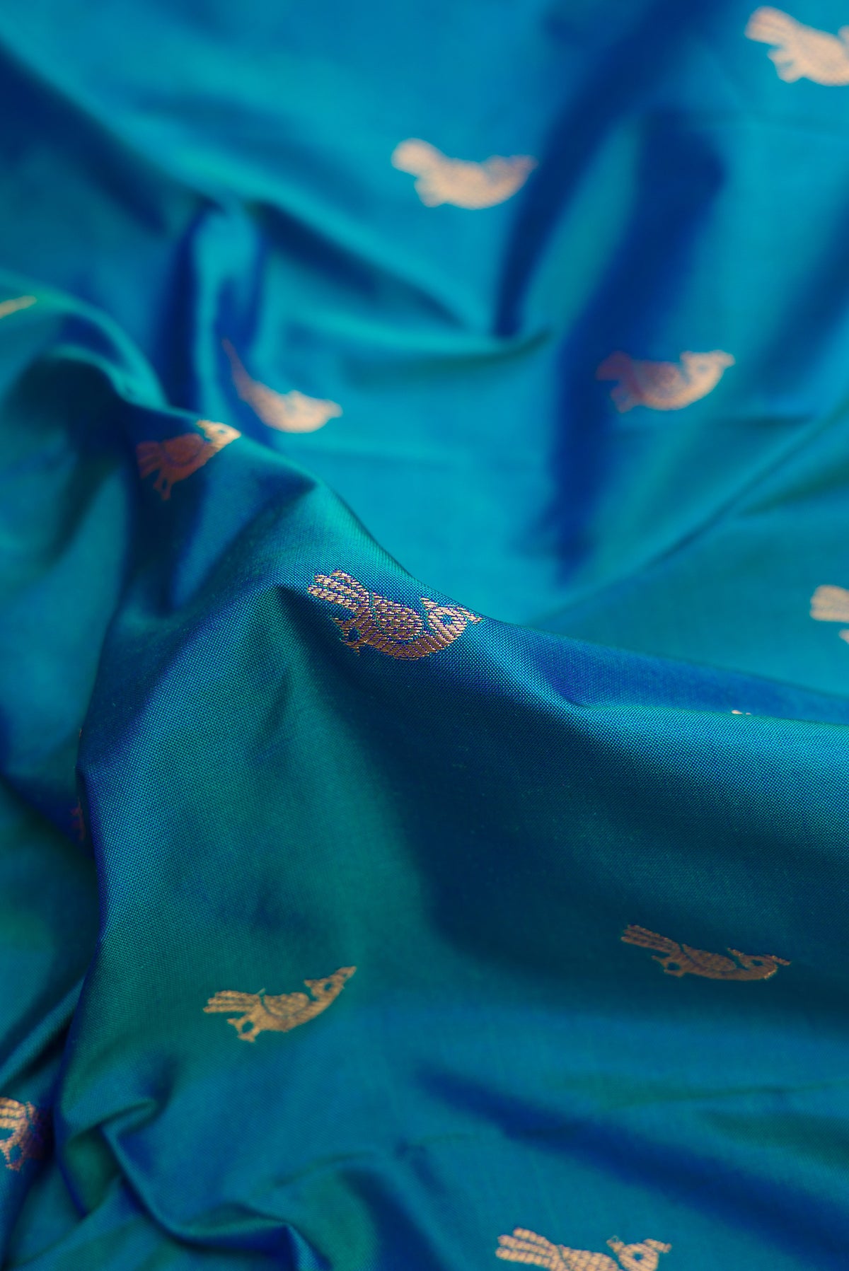 Close up of Blue Paithani Silk Saree with Zari Butta on the body and Paithani Border.  displaying folds