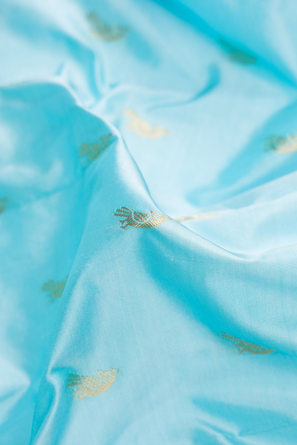 Close up of Sky Blue Paithani Silk Saree with Zari Butta on the body and Paithani Border.  displaying folds