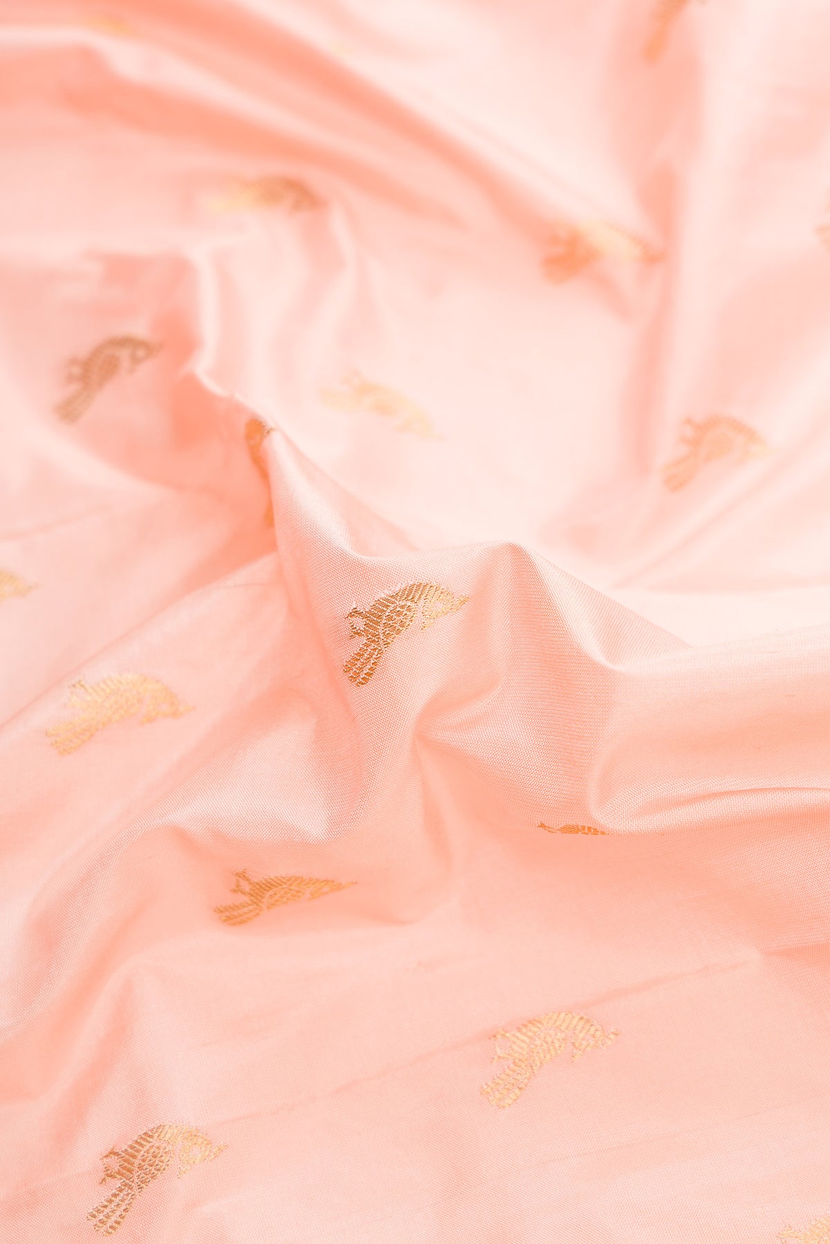Close up of Peach Paithani Silk Saree with Zari Butta on the body and Paithani Border.  displaying folds