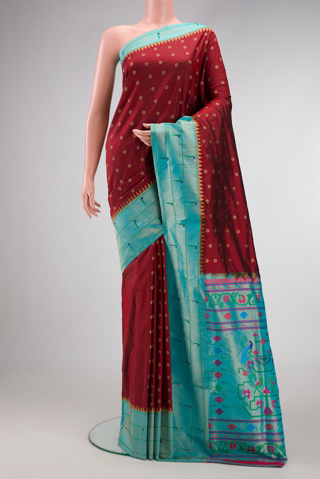 Maroon Paithani Silk Saree with Zari Butta on the body and Paithani Border.  displayed on a mannequin