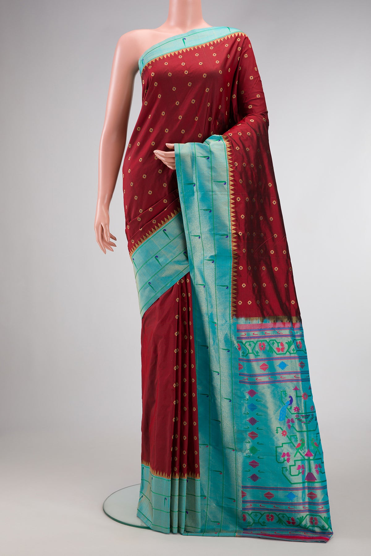 Maroon Paithani Silk Saree with Zari Butta on the body and Paithani Border.  displayed on a mannequin
