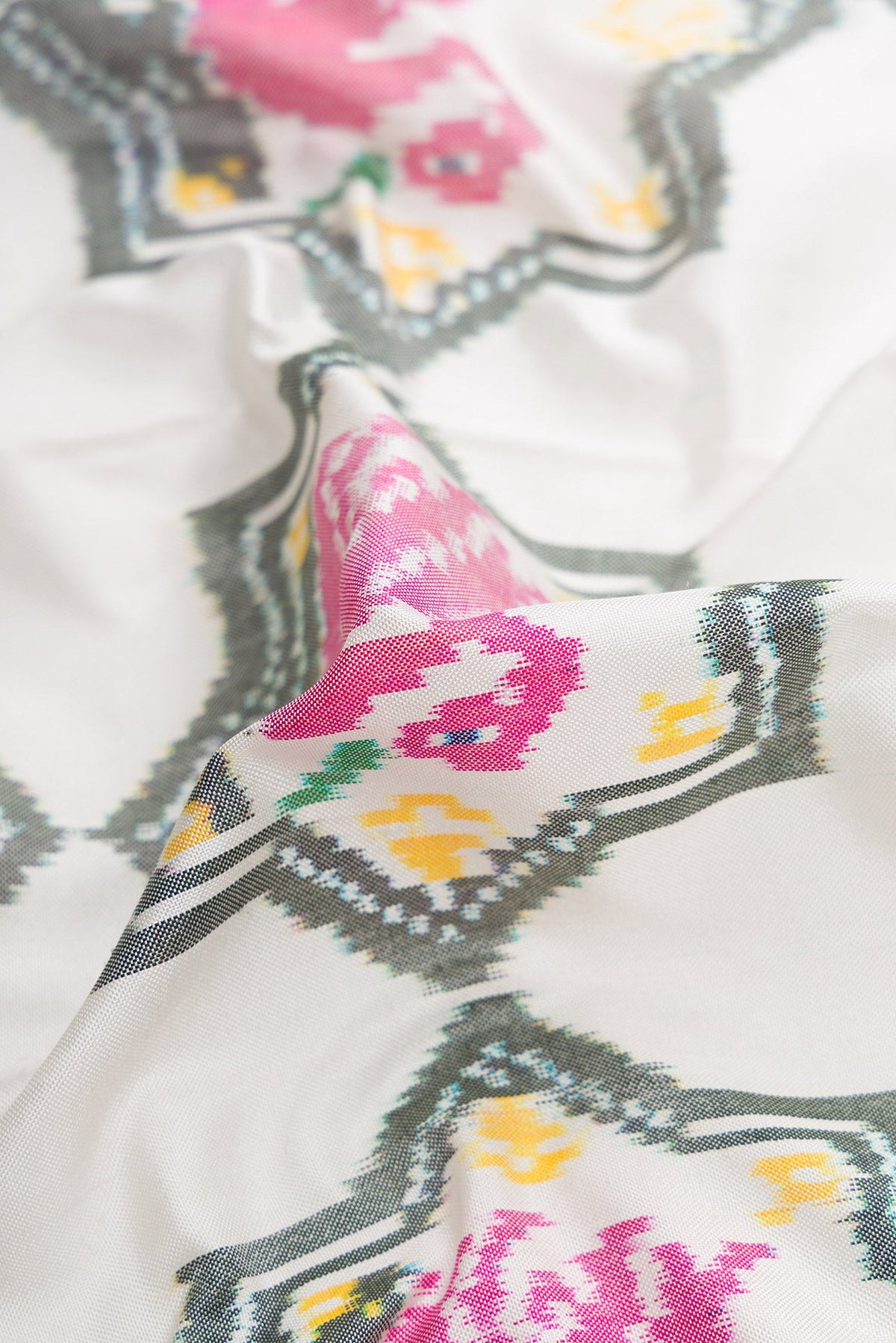 Close up of Off White Dual Tone Double Ikat Saree with Ikat Print on the body and Ikat Border.  displaying folds