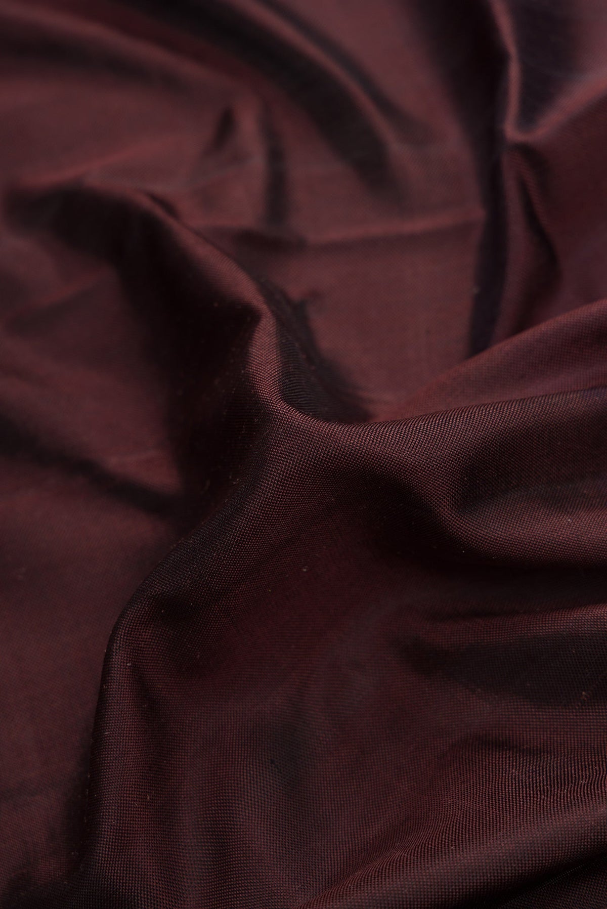 Close up of Brown Dual Tone Double Ikat Saree with Plain Body and Ikat Border.  displaying folds