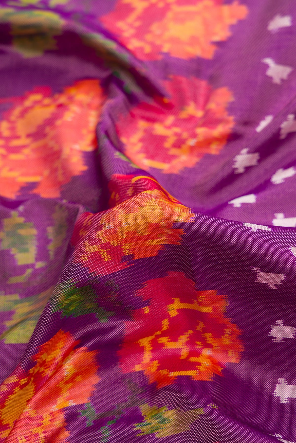 Close up of Purple Dual Tone Double Ikat Saree with Ikat Print on the body and Thread Border.  displaying folds
