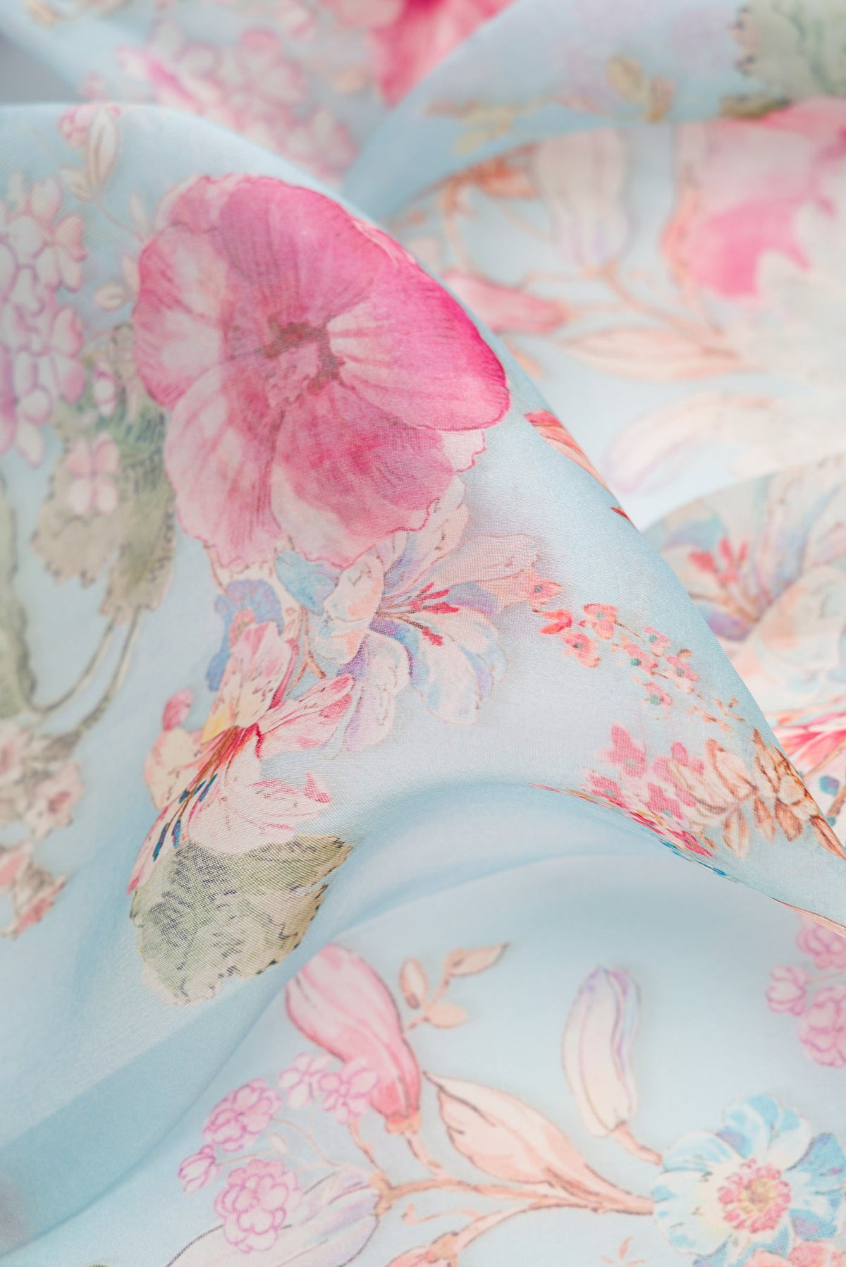 Close up of Sky Blue Dual Tone Organza Silk Saree with Printed design on the body and Zari And Thread Border.  displaying folds