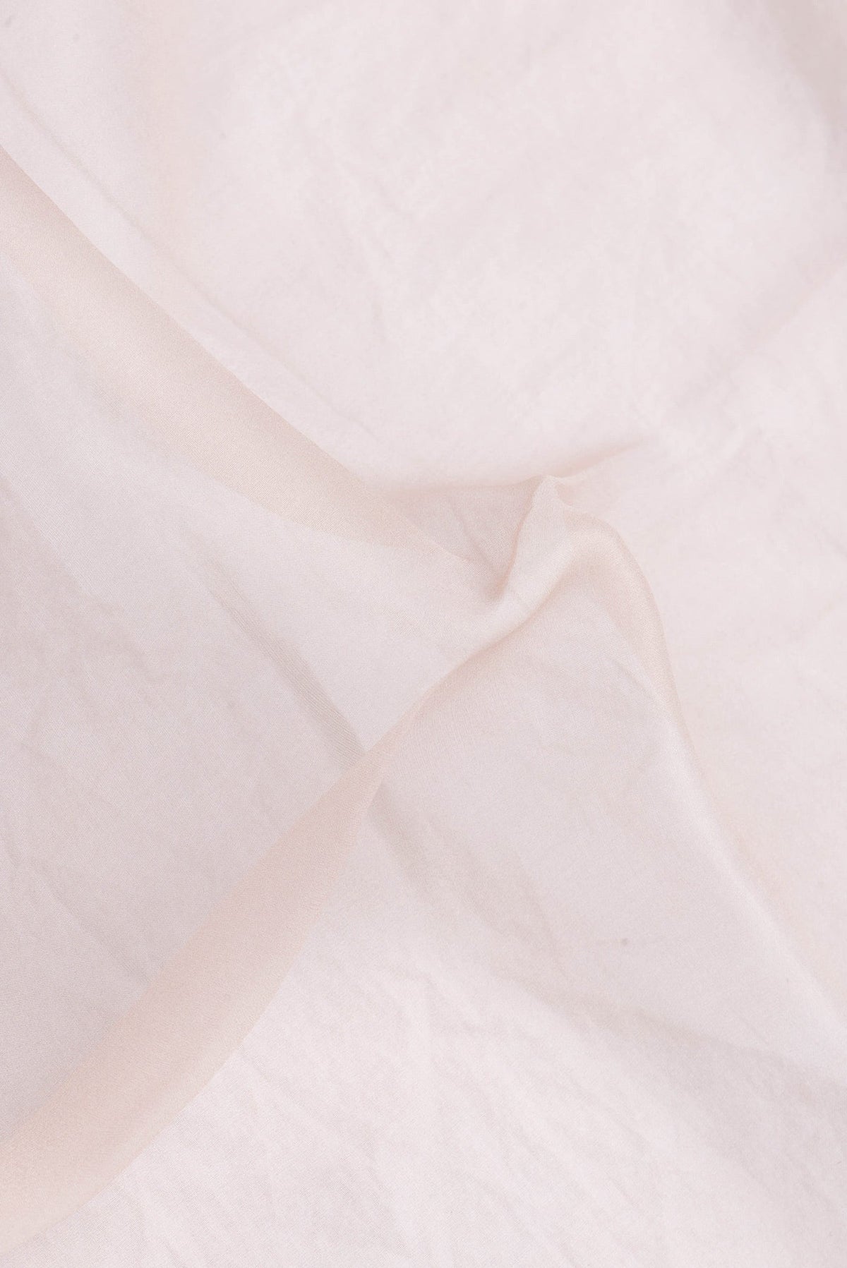 Close up of Rose Gold Dual Tone Organza Silk Saree with Plain Body and Printed Border.  displaying folds