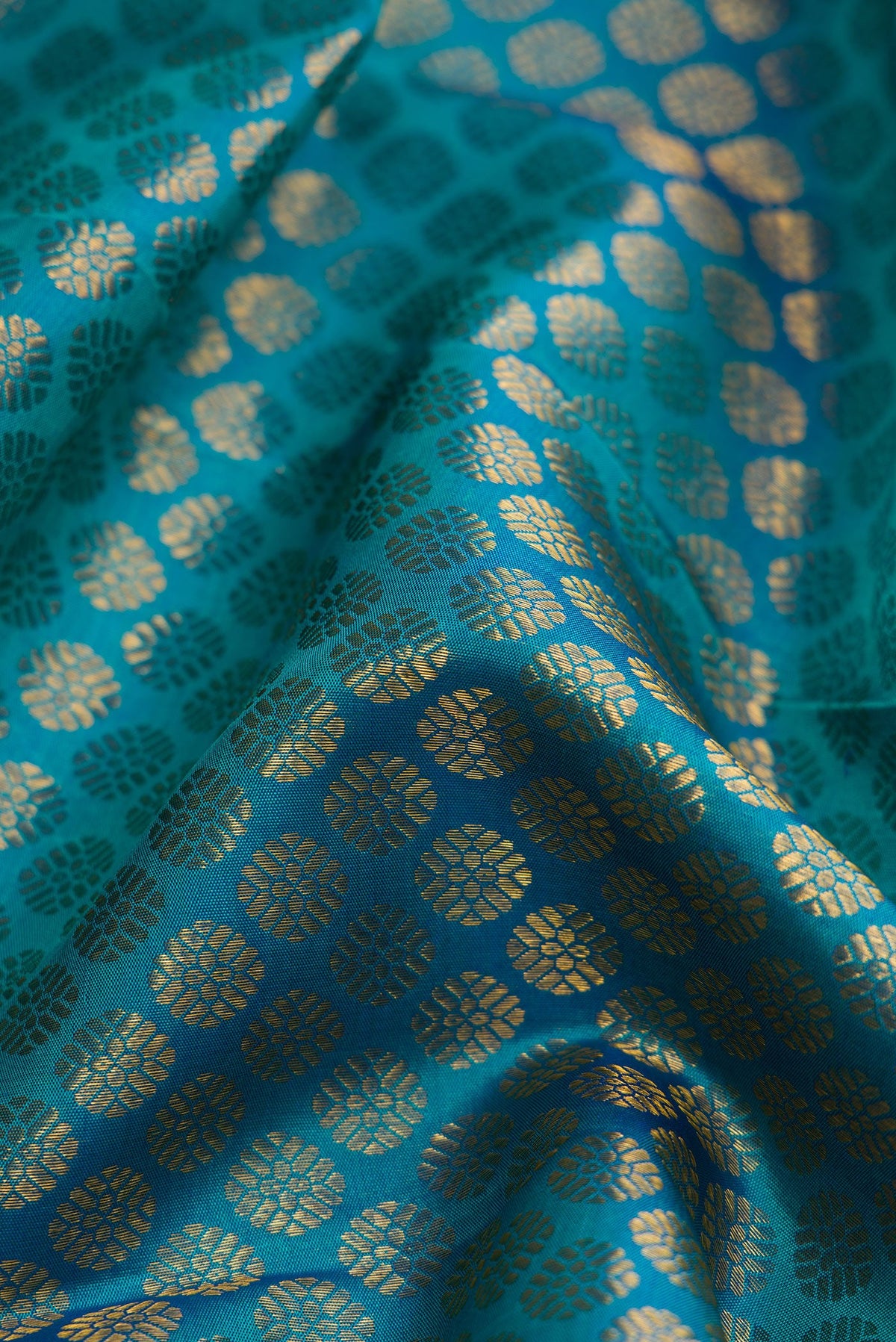 Close up of Peacock Blue Dual Tone Kanchipuram Silk Saree with Zari Brocade on the body and Zari Border.  displaying folds