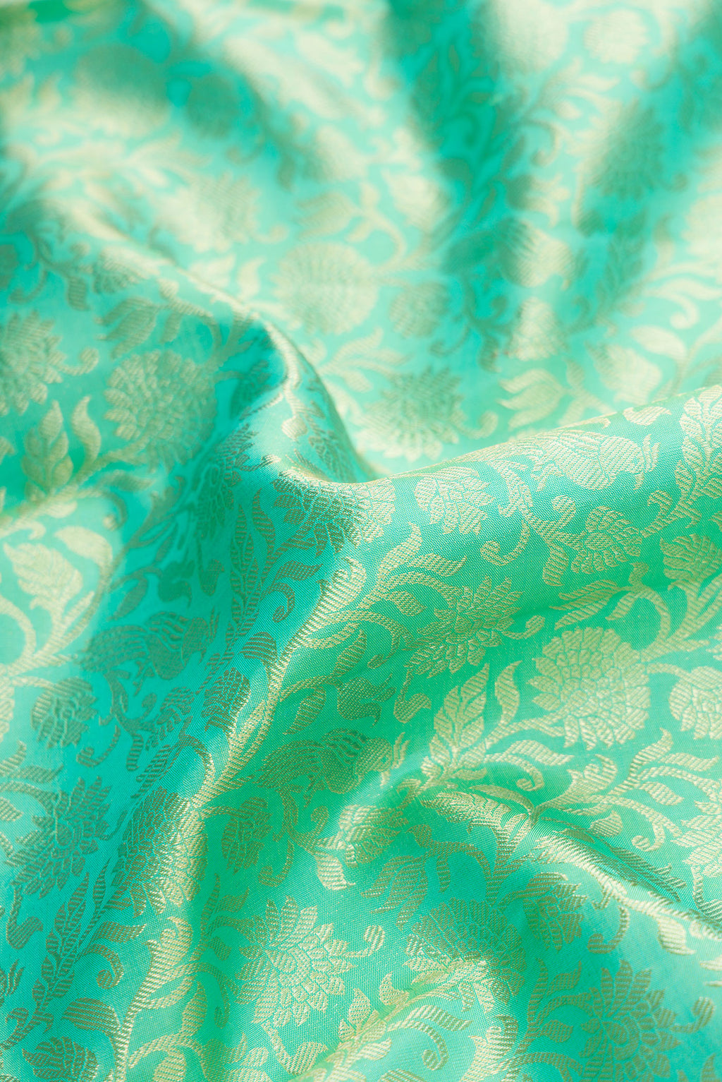 Close up of Turquoise Kanchipuram Silk Saree with Zari Brocade on the body and Zari Border.  displaying folds