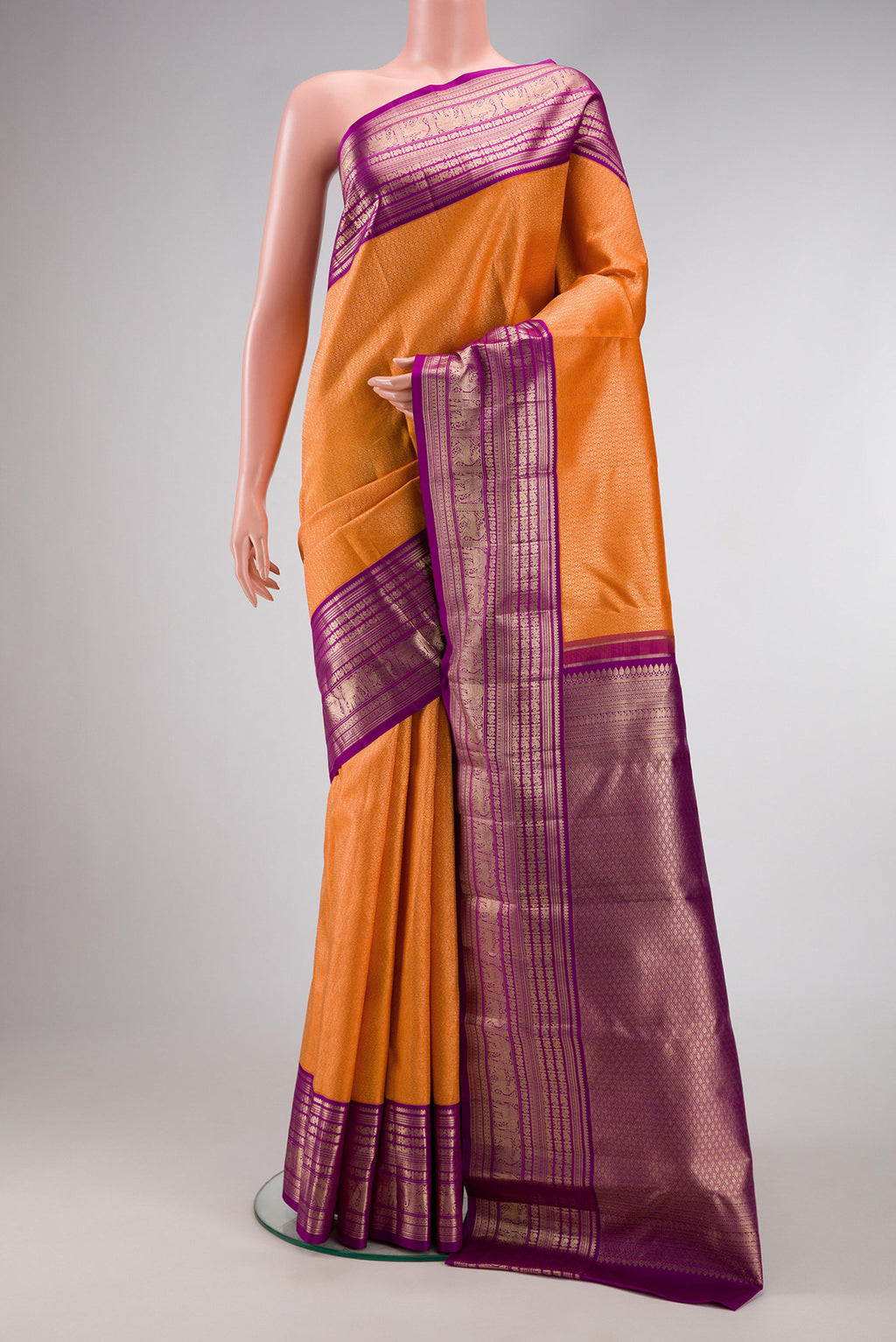 Orange Kanchipuram Silk Saree with Zari Brocade on the body and Zari Border.  displayed on a mannequin