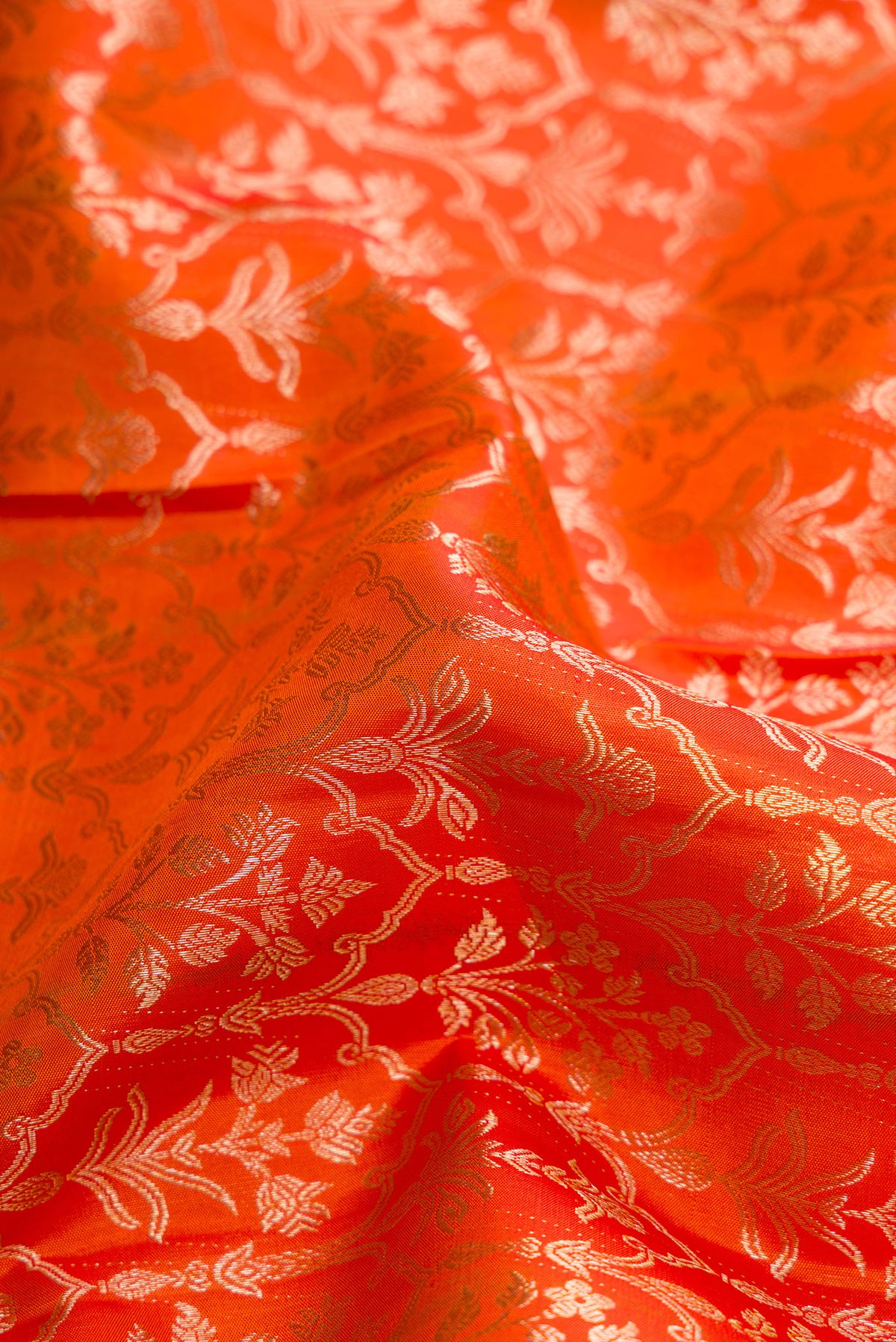 Close up of Orange Kanchipuram Silk Saree with Zari Brocade on the body and Zari Border.  displaying folds