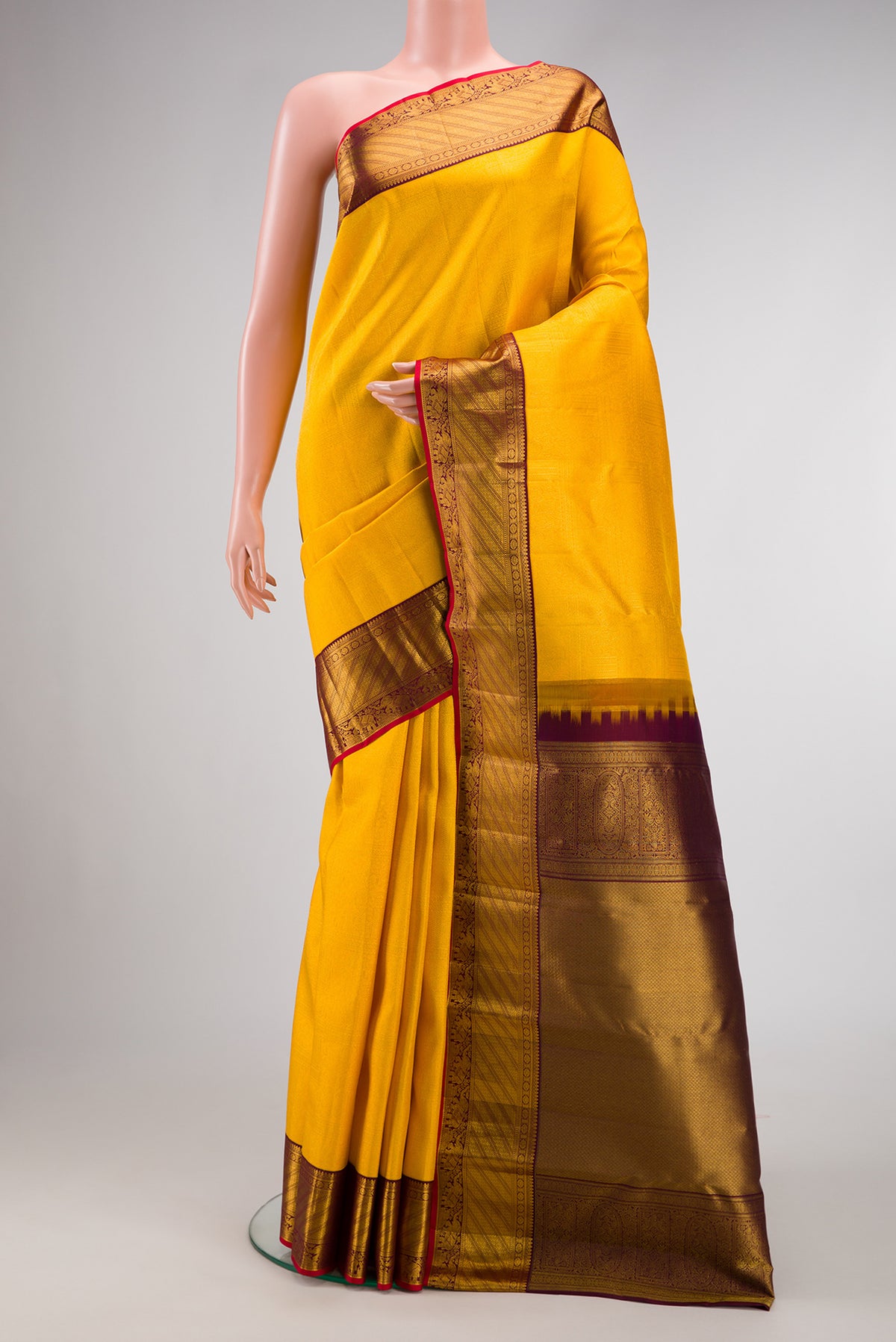 Yellow Kanjivaram Silk Saree with Zari Brocade on the body and Zari Border.  displayed on a mannequin