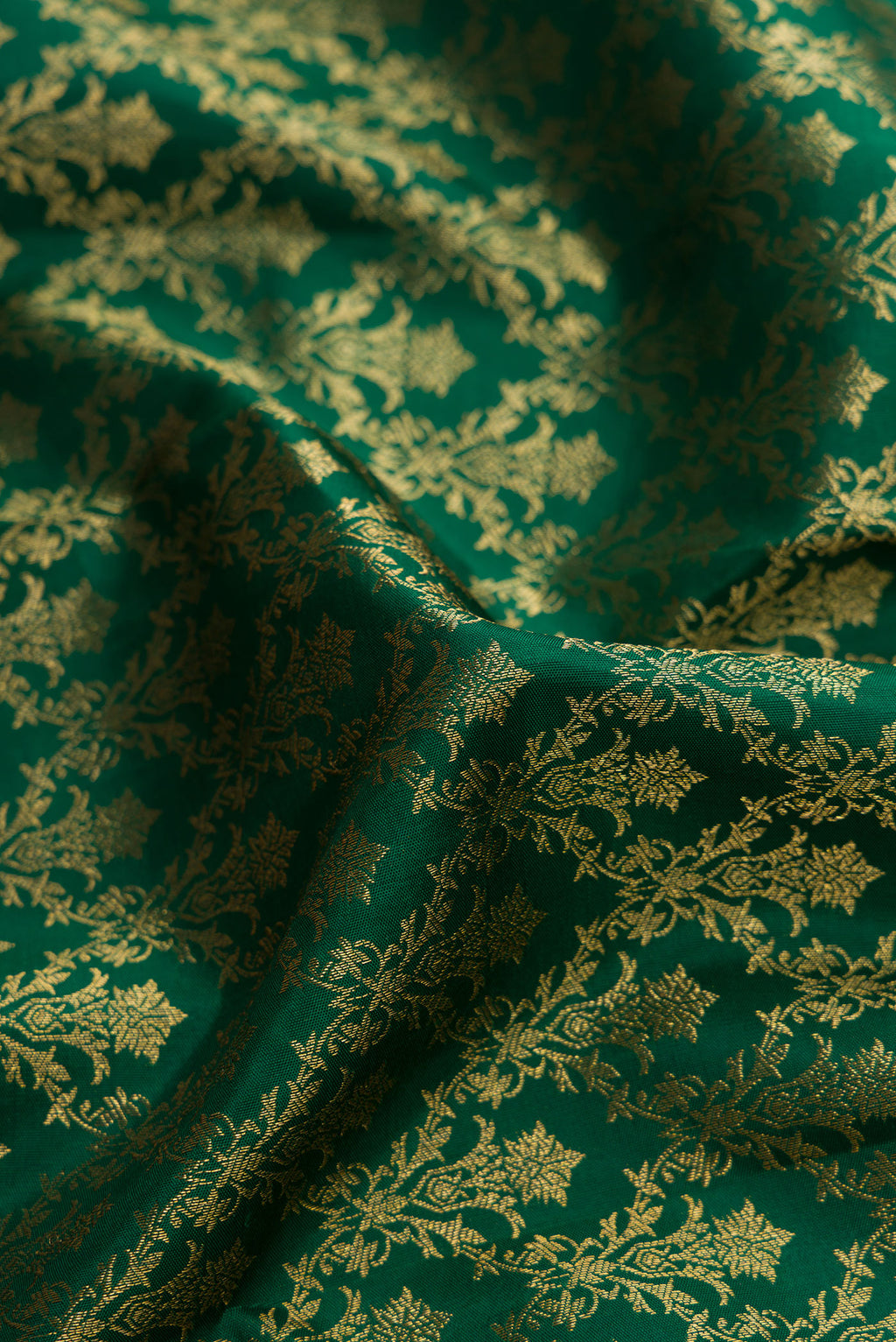 Close up of Bottle Green Kanjivaram Silk Saree with Zari Brocade on the body and Zari Border.  displaying folds