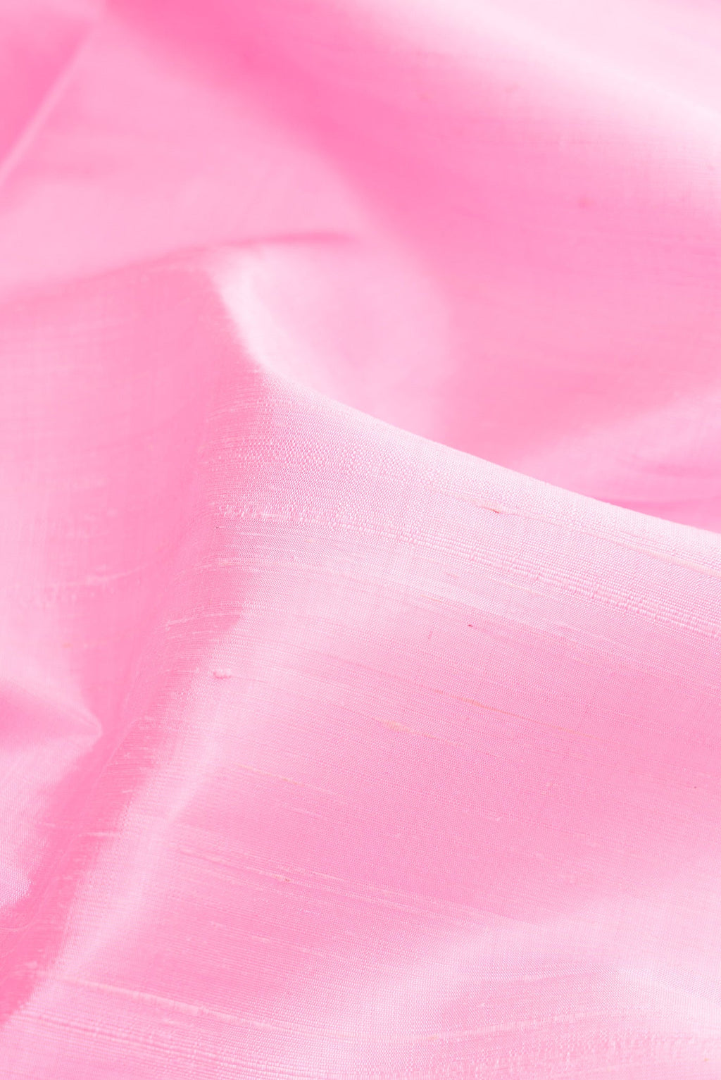 Close up of Pink Raw Silk Saree with Plain Body and Zari Border.  displaying folds