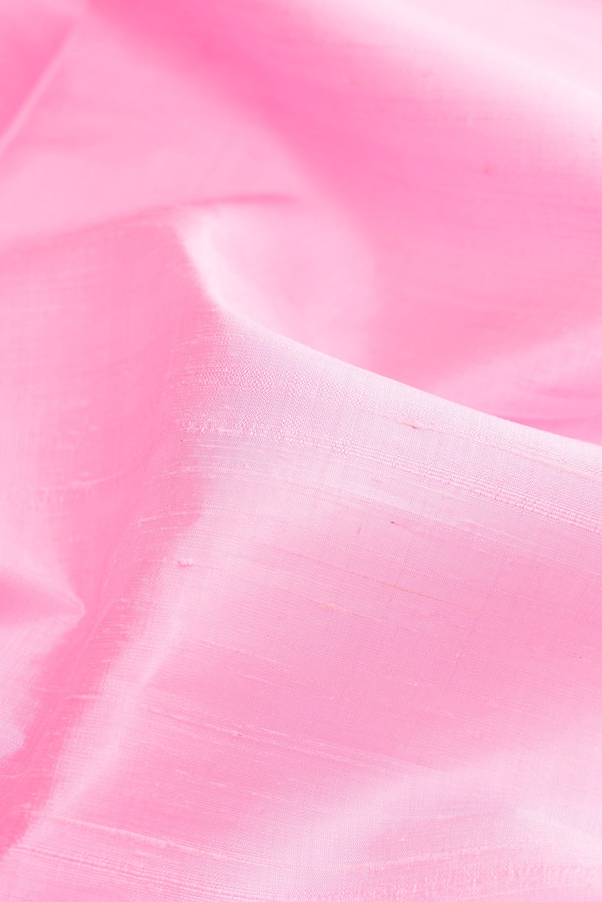 Close up of Pink Raw Silk Saree with Plain Body and Zari Border.  displaying folds