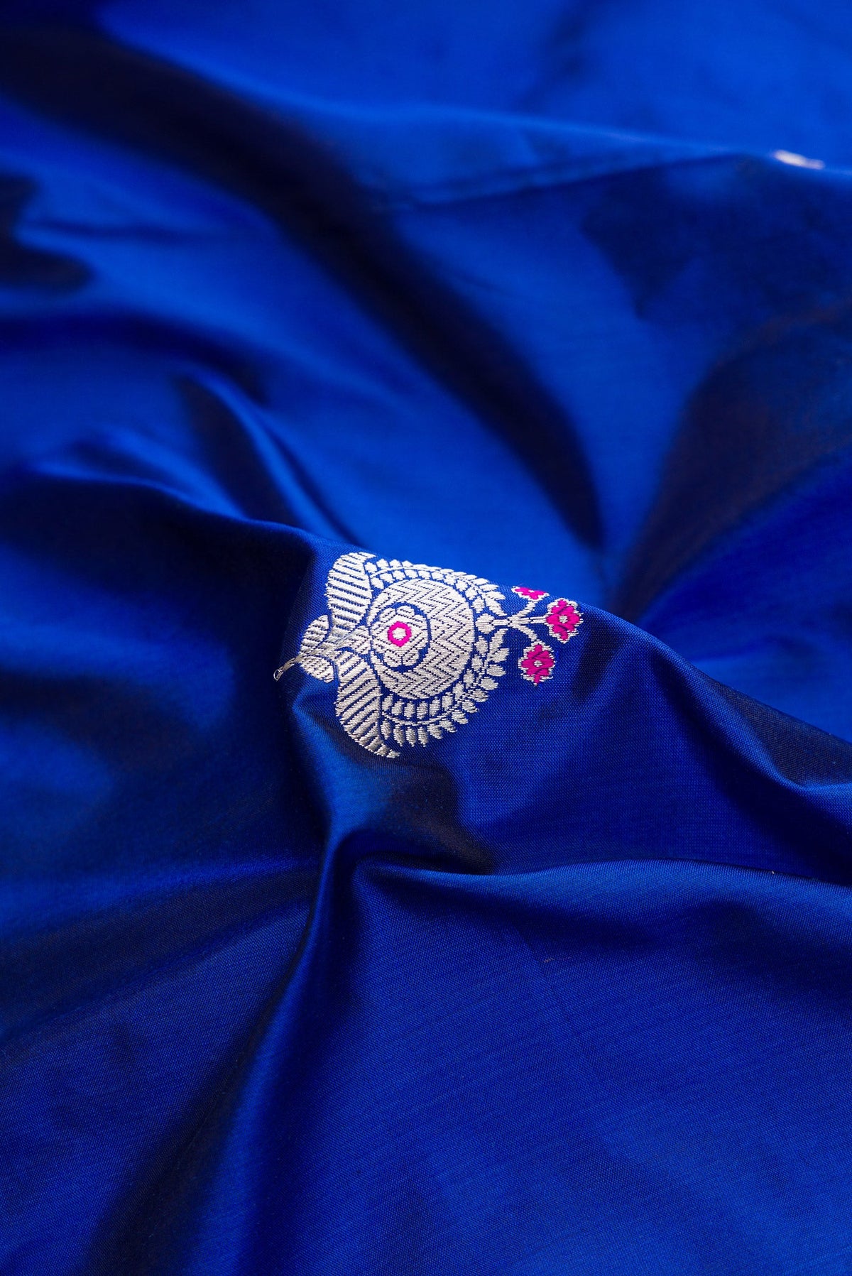 Close up of Royal Blue Dual Tone Banarasi Silk Saree with Zari And Thread Butta on the body and Fancy Border.  displaying folds