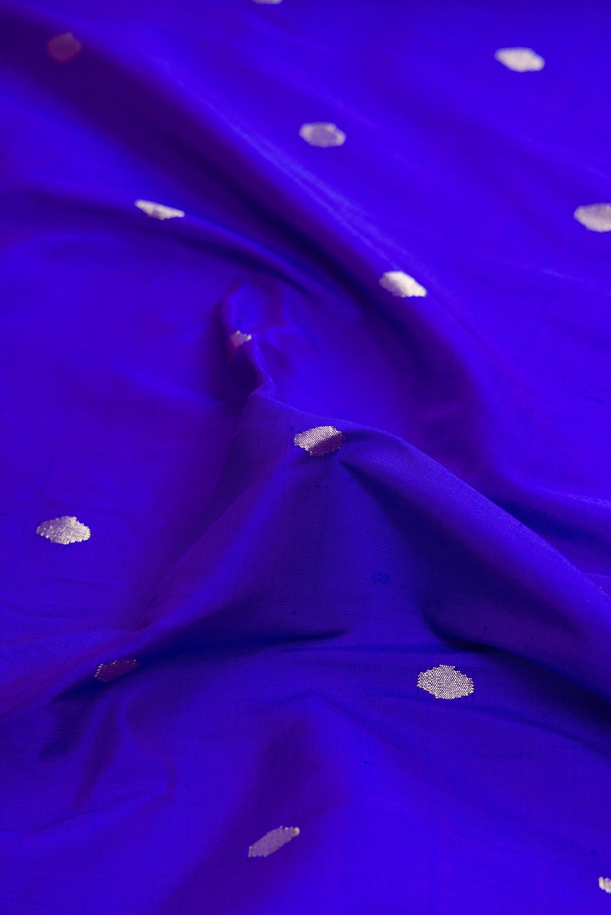 Close up of Pure Silk Pure Zari Royal Blue Dual Tone Paithani Saree with Zari Butta on the body and Paithani Border.  displaying folds