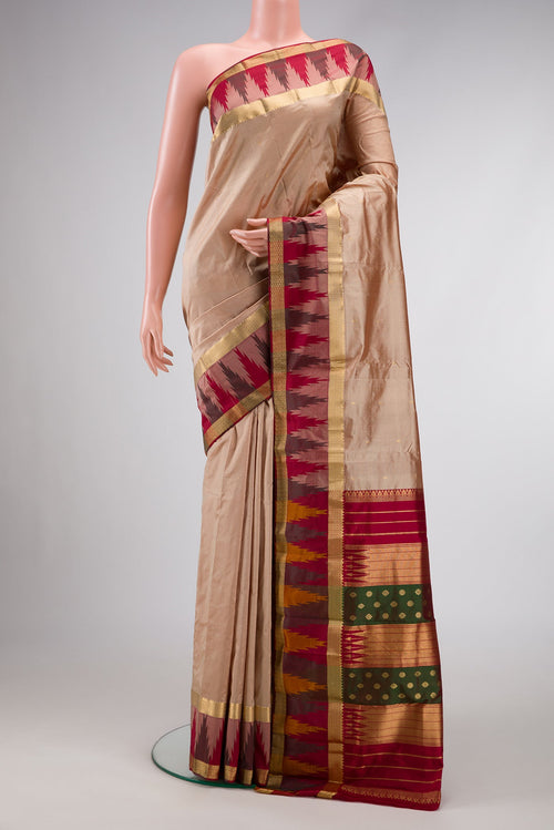 Beige Dual Tone Kanchipuram Silk Saree with Zari Butta on the body and Temple Border.  displayed on a mannequin