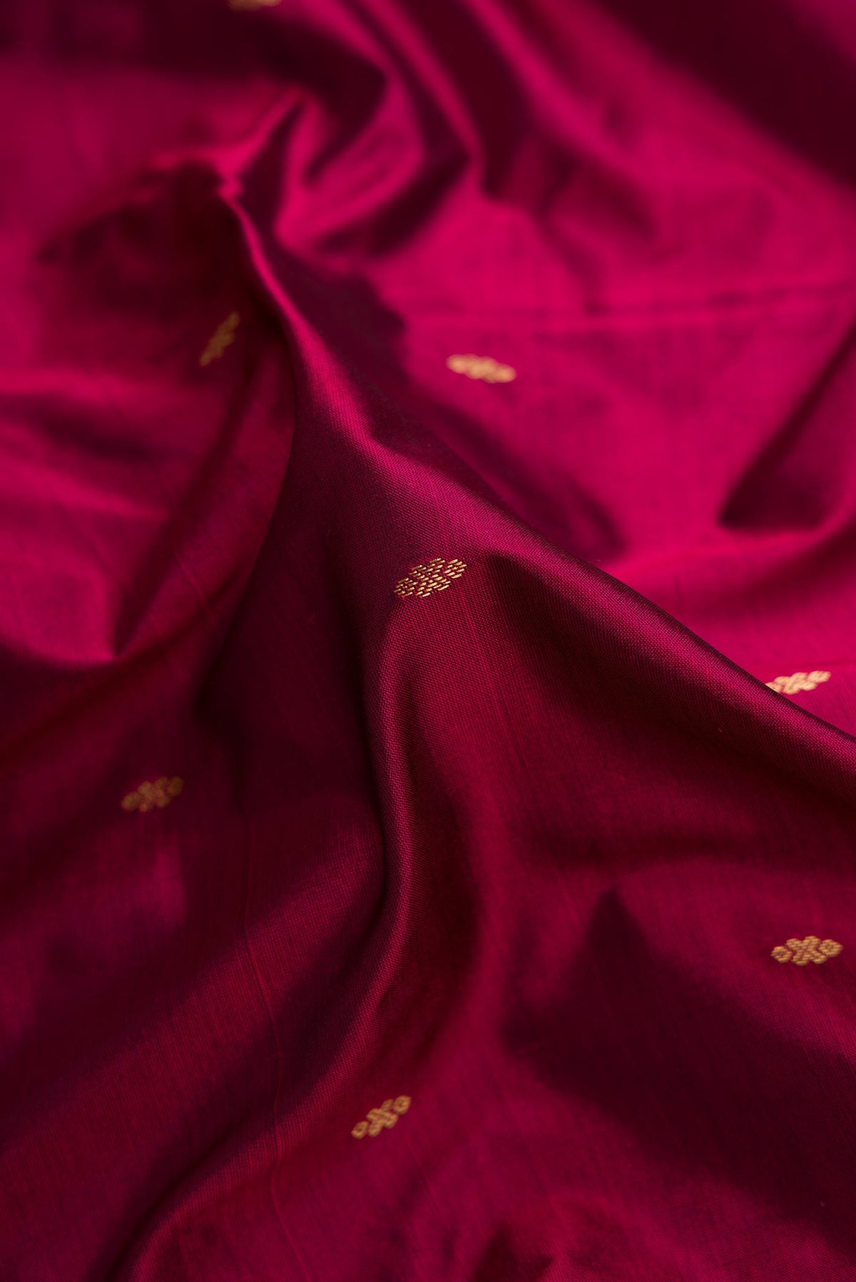 Close up of Burgundy Dual Tone Kanchipuram Silk Saree with Zari Butta on the body and Temple Border.  displaying folds
