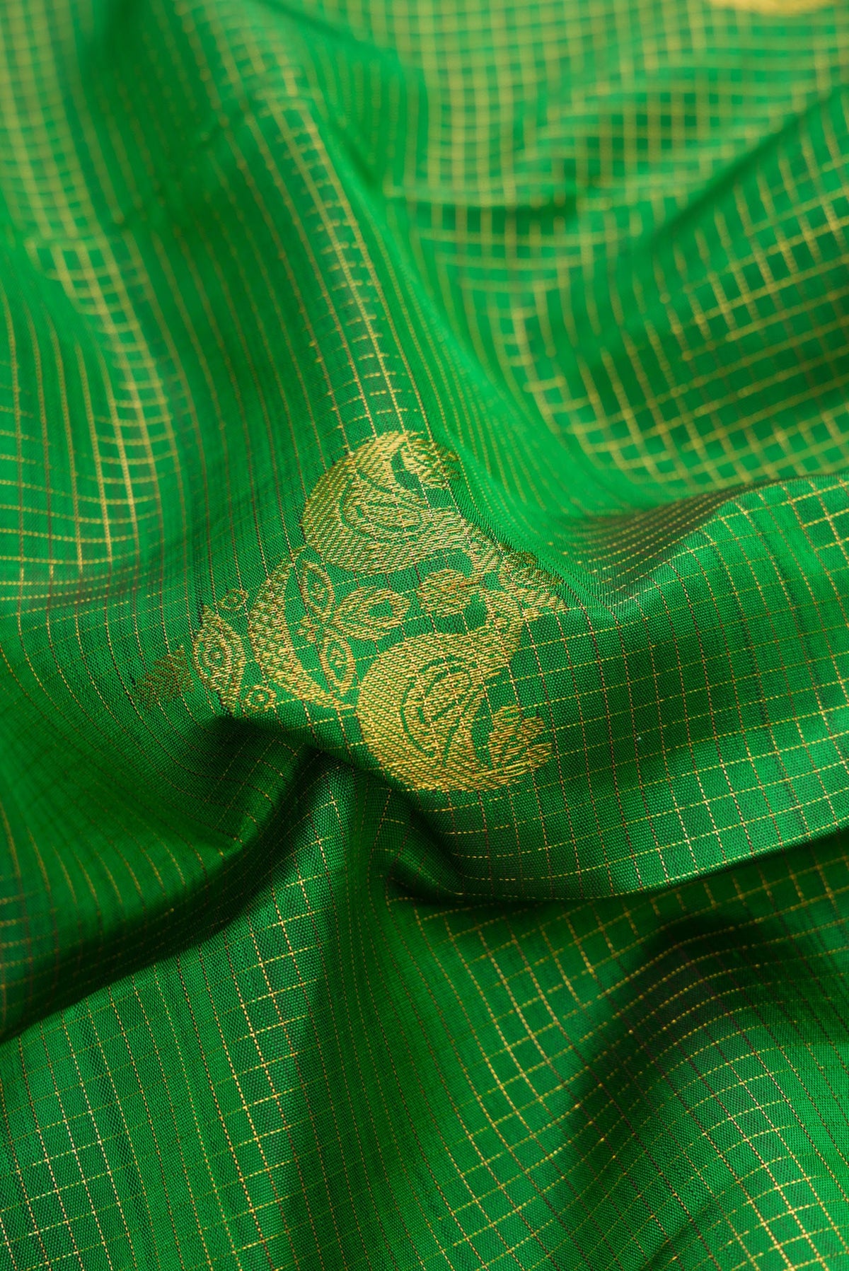 Close up of Bottle Green Dual Tone Kanchipuram Silk Saree with Checked design on the body and Zari Border.  displaying folds