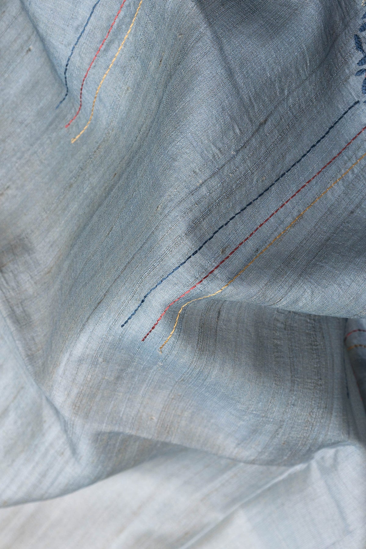 Close up of Grey Dual Tone Tussar Silk Saree with Embroidery on the body and Fancy Border.  displaying folds