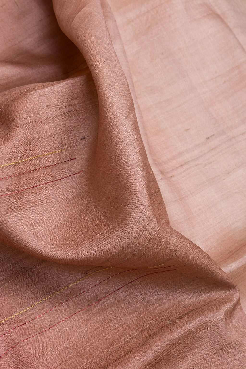 Close up of Rose Gold Dual Tone Tussar Silk Saree with Embroidery on the body and Fancy Border.  displaying folds
