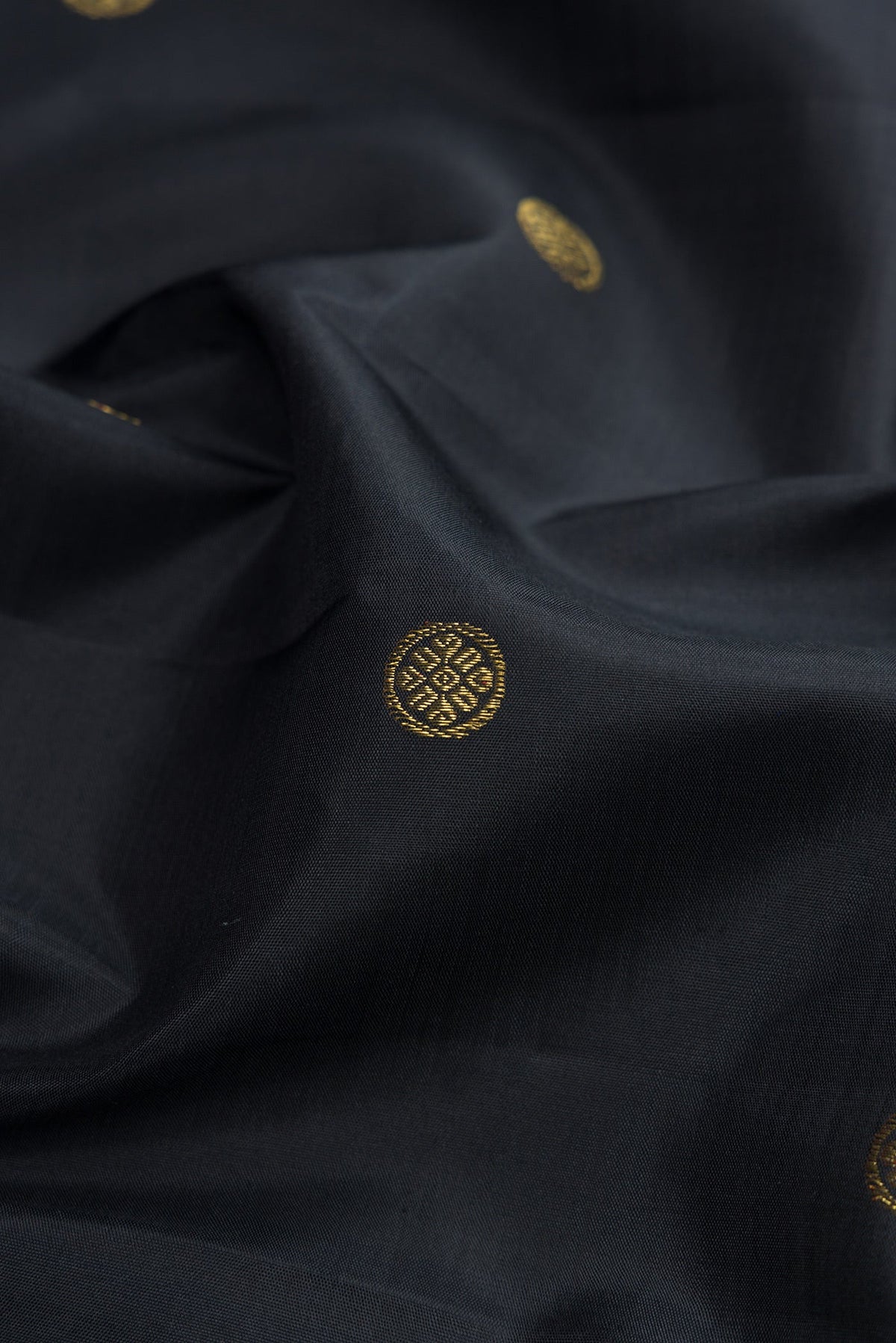 Close up of Black Kanchipuram Silk Saree with Zari Butta on the body and Checks Border.  displaying folds