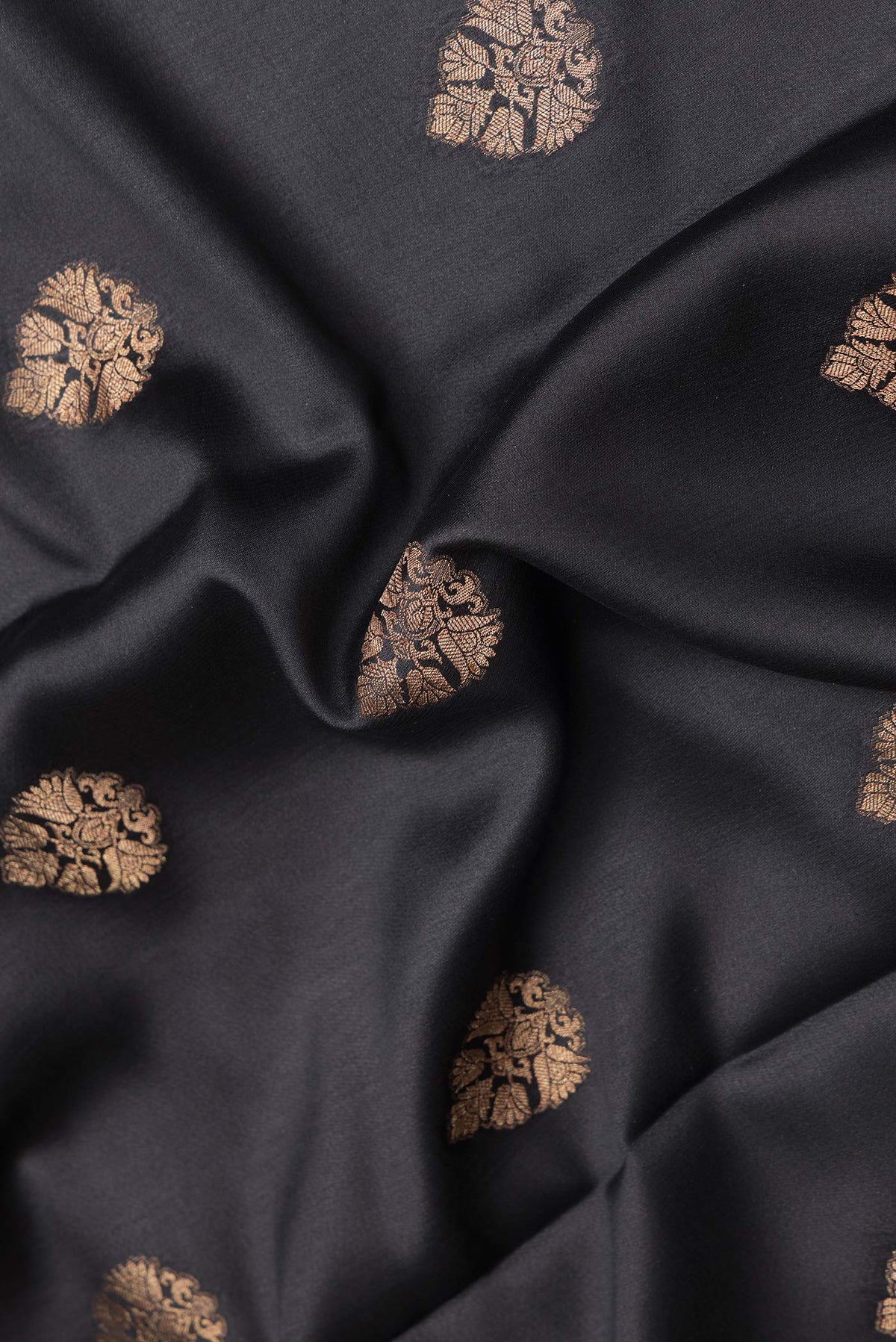 Close up of Black Dual Tone Mysore Silk Saree with Zari Butta on the body and Zari Border.  displaying folds