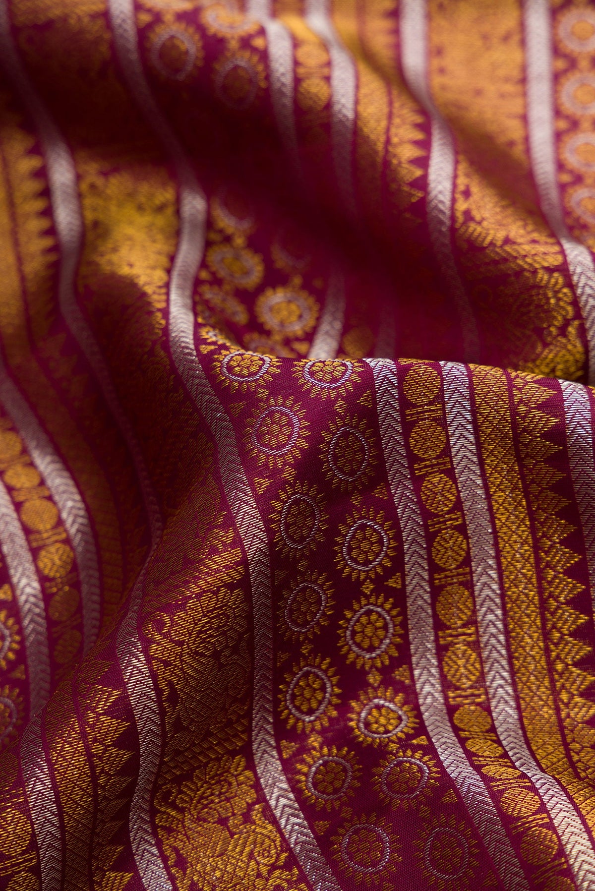 Close up of Burgundy Dual Tone Kanchipuram Silk Saree with Zari Brocade on the body and Zari Border.  displaying folds