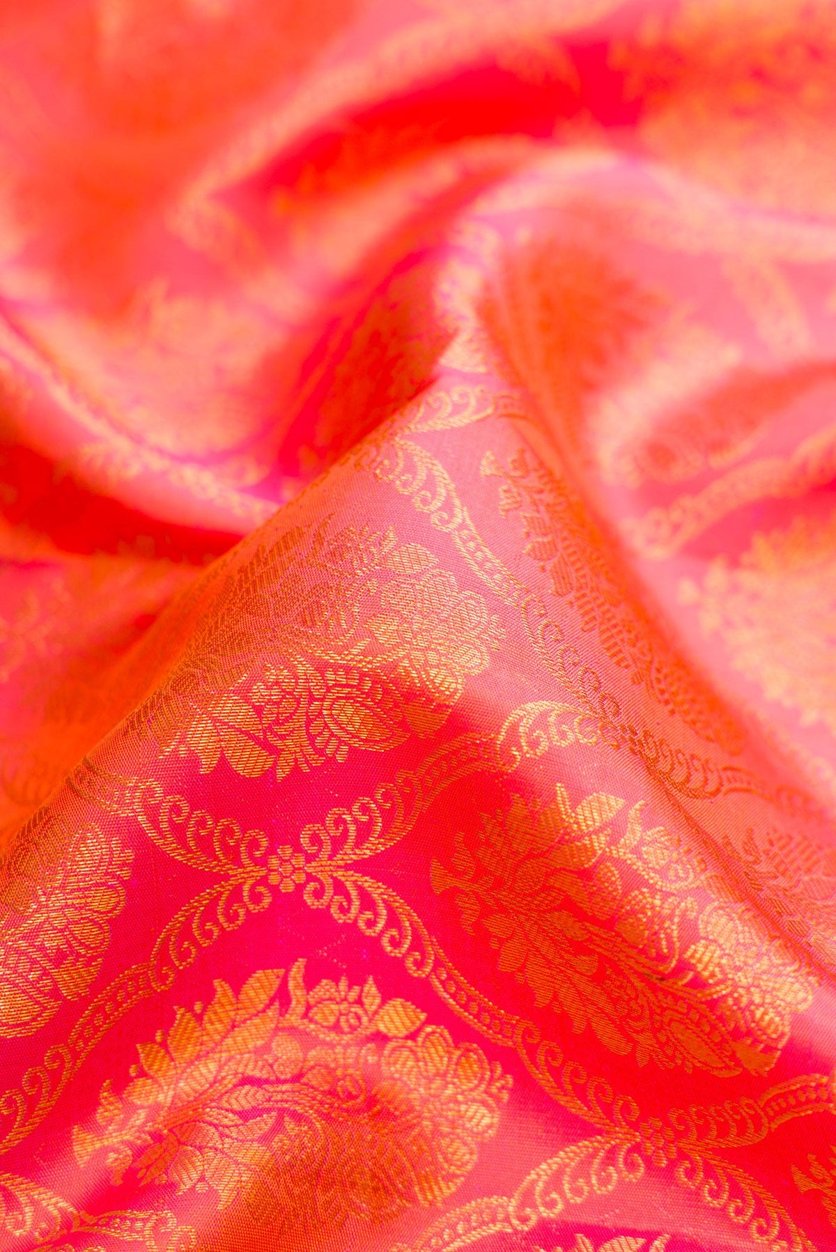 Close up of Peach Dual Tone Kanchipuram Silk Saree with Zari Brocade on the body and Zari Border.  displaying folds