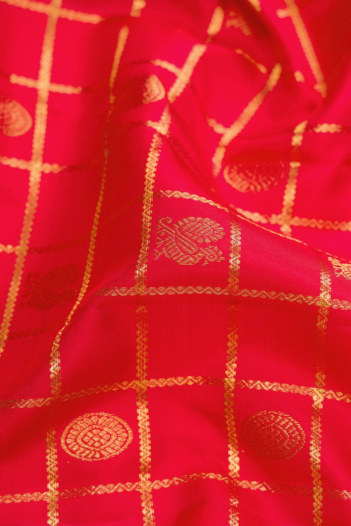 Close up of Red Dual Tone Kanchipuram Silk Saree with Checked design on the body and Zari Border.  displaying folds