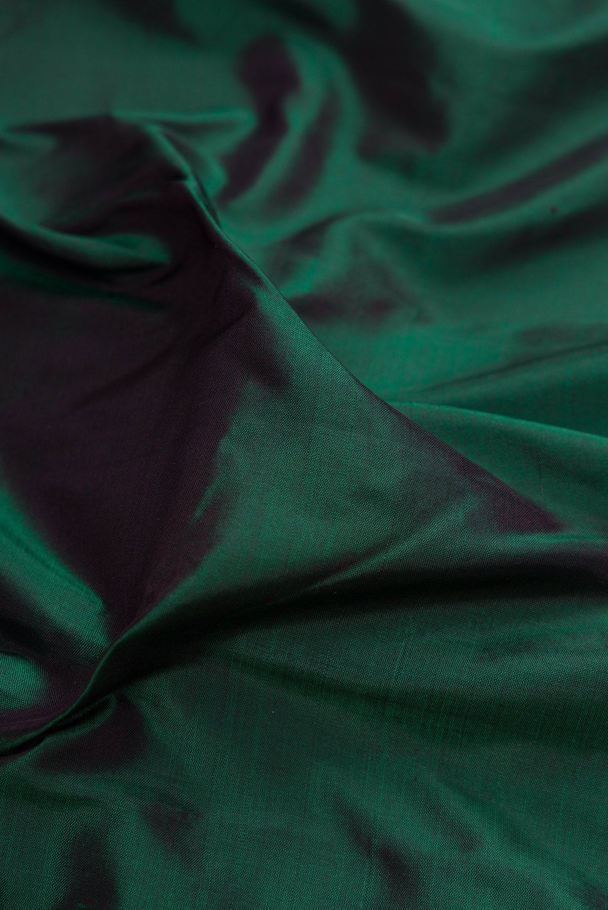 Close up of Bottle Green Kanjivaram Silk Saree with Plain Body and Zari Border.  displaying folds