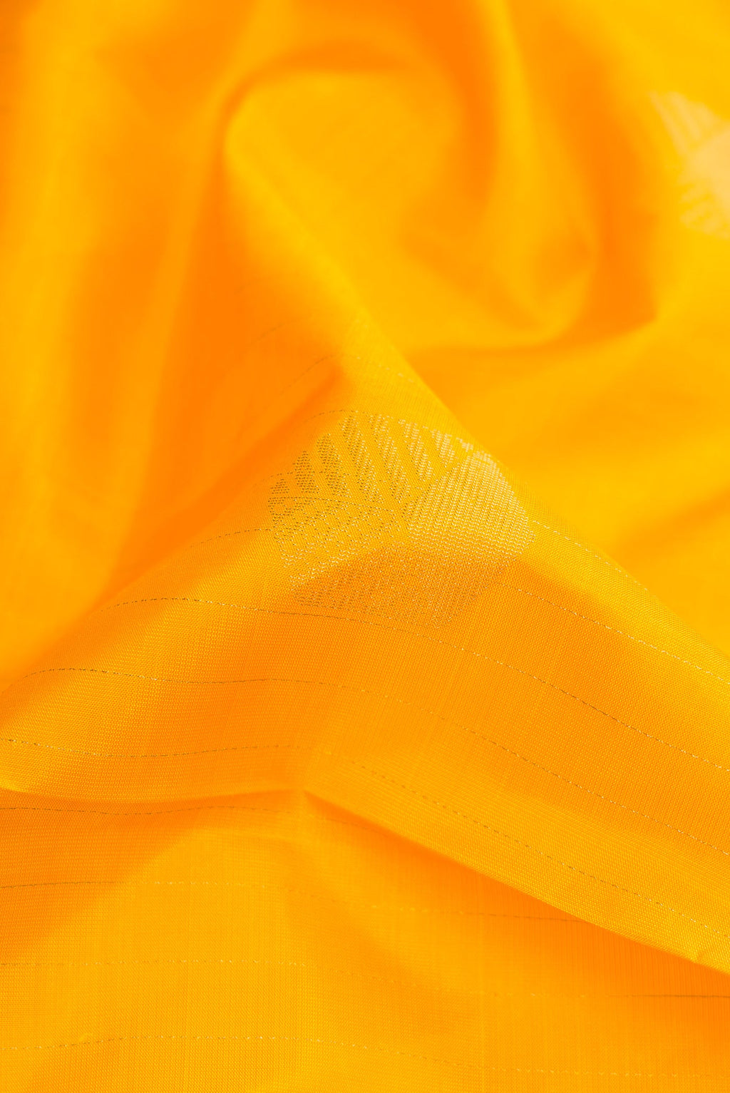 Close up of Yellow Dual Tone Soft Silk Saree with Zari Butta on the body and Without Border.  displaying folds