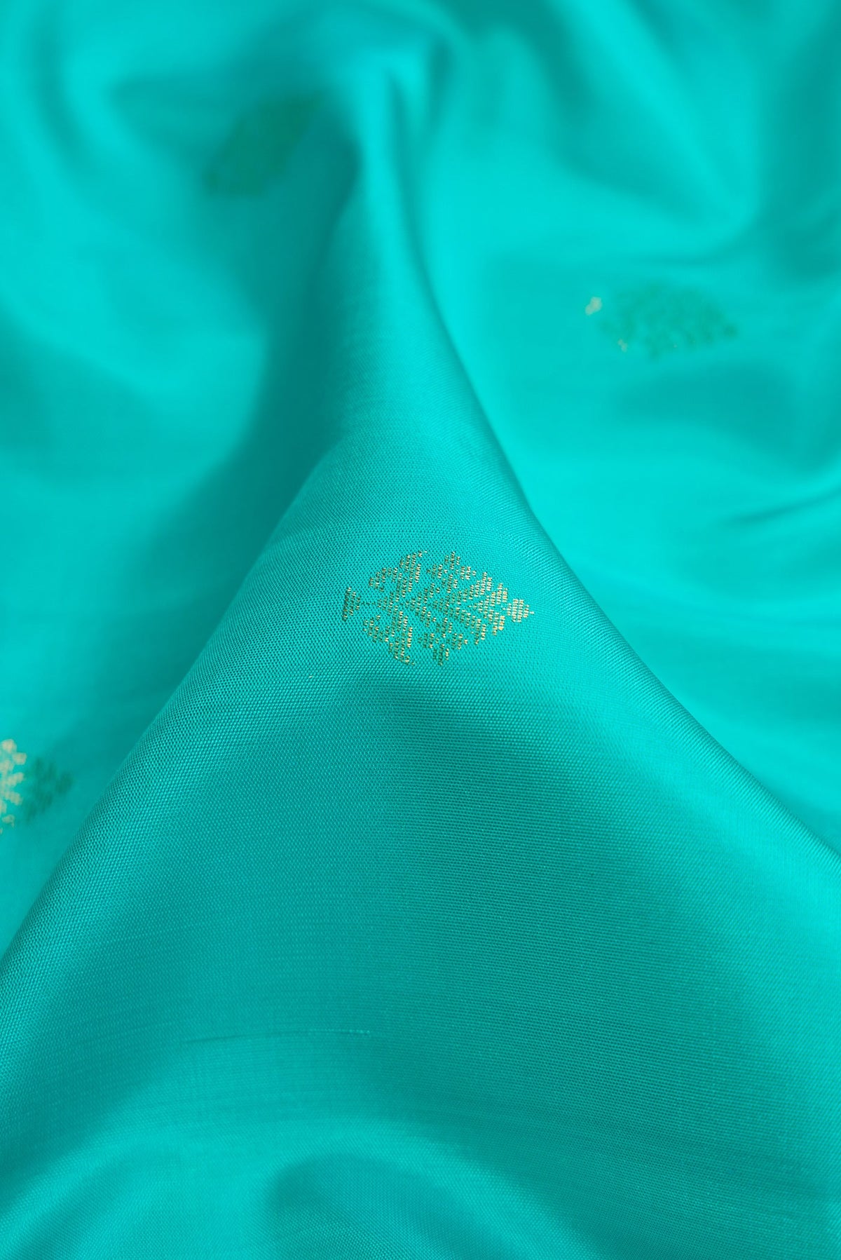 Close up of Sky Blue Dual Tone Soft Silk Saree with Zari Butta on the body and Zari Border.  displaying folds