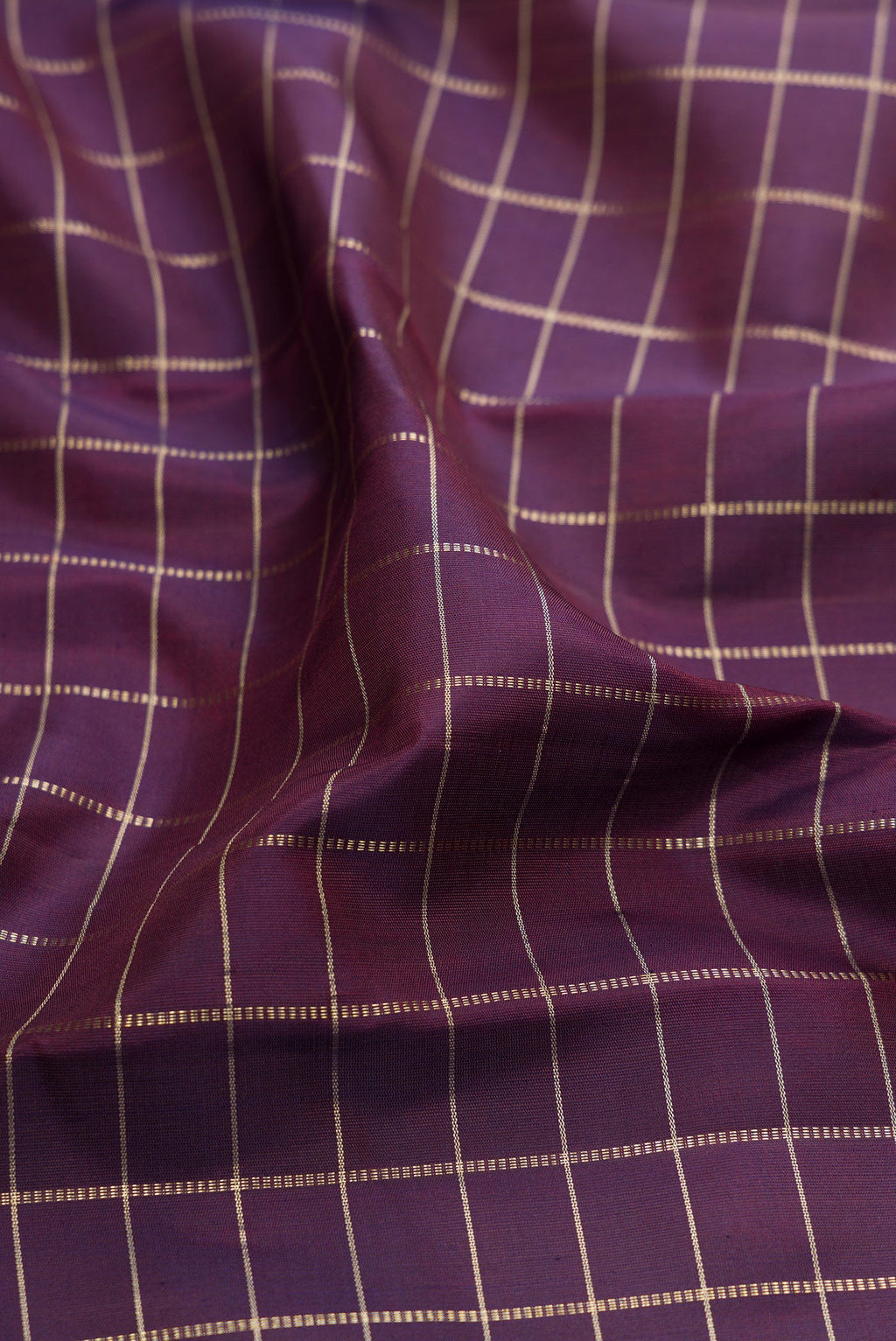 Close up of Purple Kanchipuram Silk Saree with Checked design on the body and Plain Border.  displaying folds