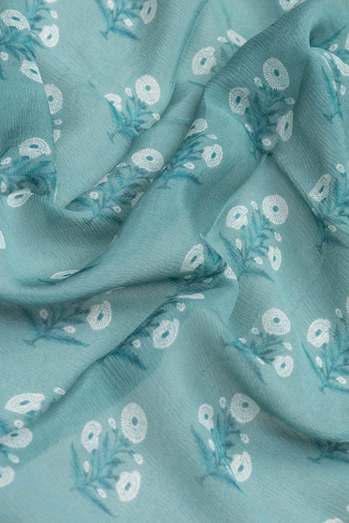 Close up of Maya Blue Dual Tone Mysore Chiffon Saree with Printed design on the body and Zari Border.  displaying folds