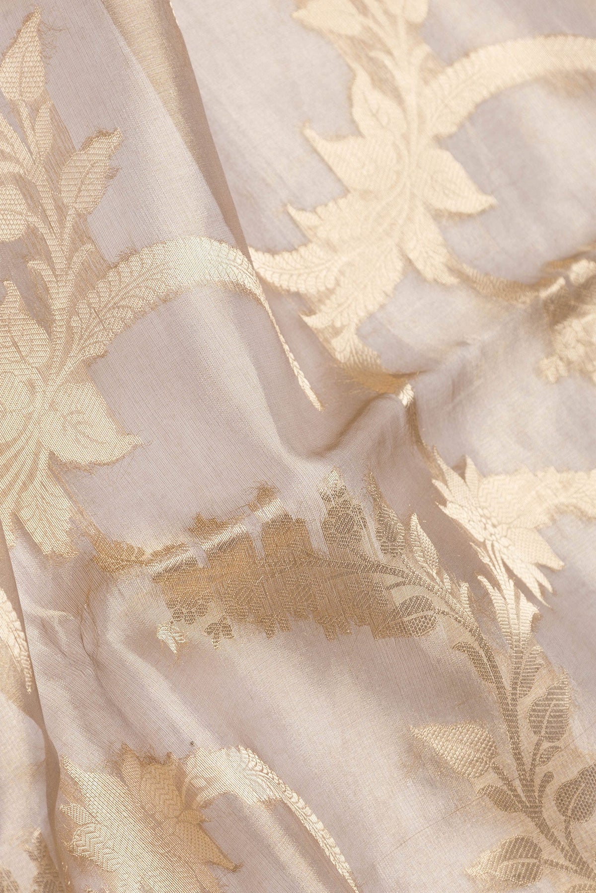 Close up of Gold Dual Tone Organza Silk Saree with Zari Brocade on the body and Zari Border.  displaying folds